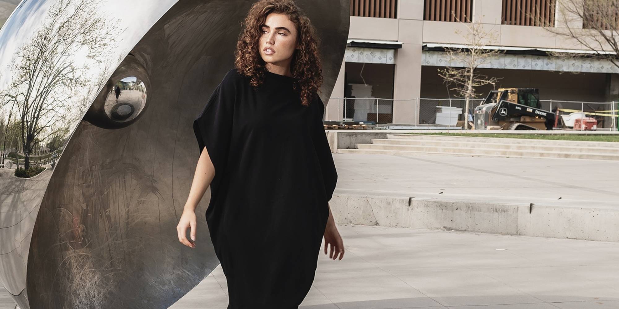 Someone wearing a black shift dress by Malaika NY.