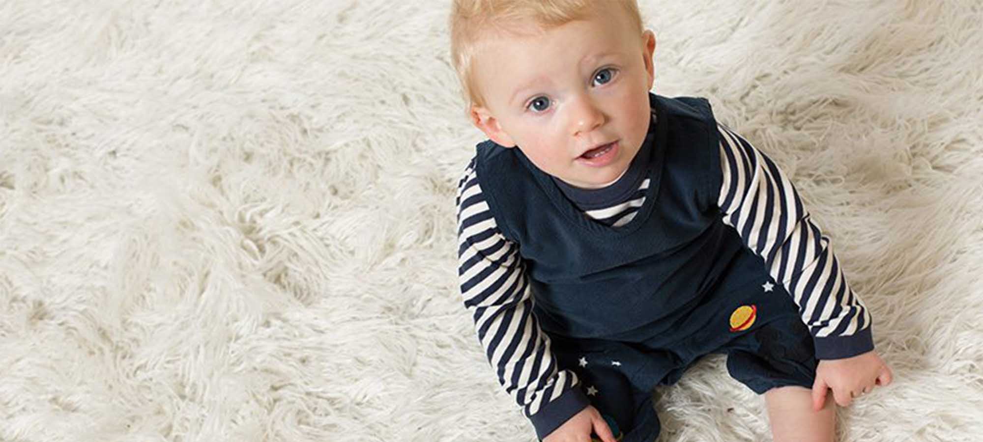 baby wearing little green radicals navy jumpsuit