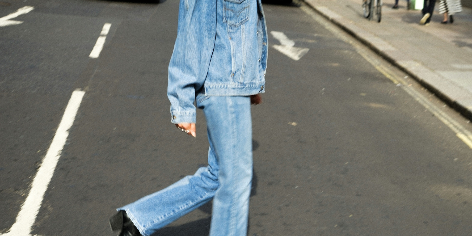 Someone in upcycled denim jacket and jeans by ELV Denim.