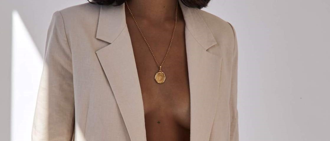 Ethical luxury jewellery brand Holly Ryan featuring a woman of colour in a gold necklace