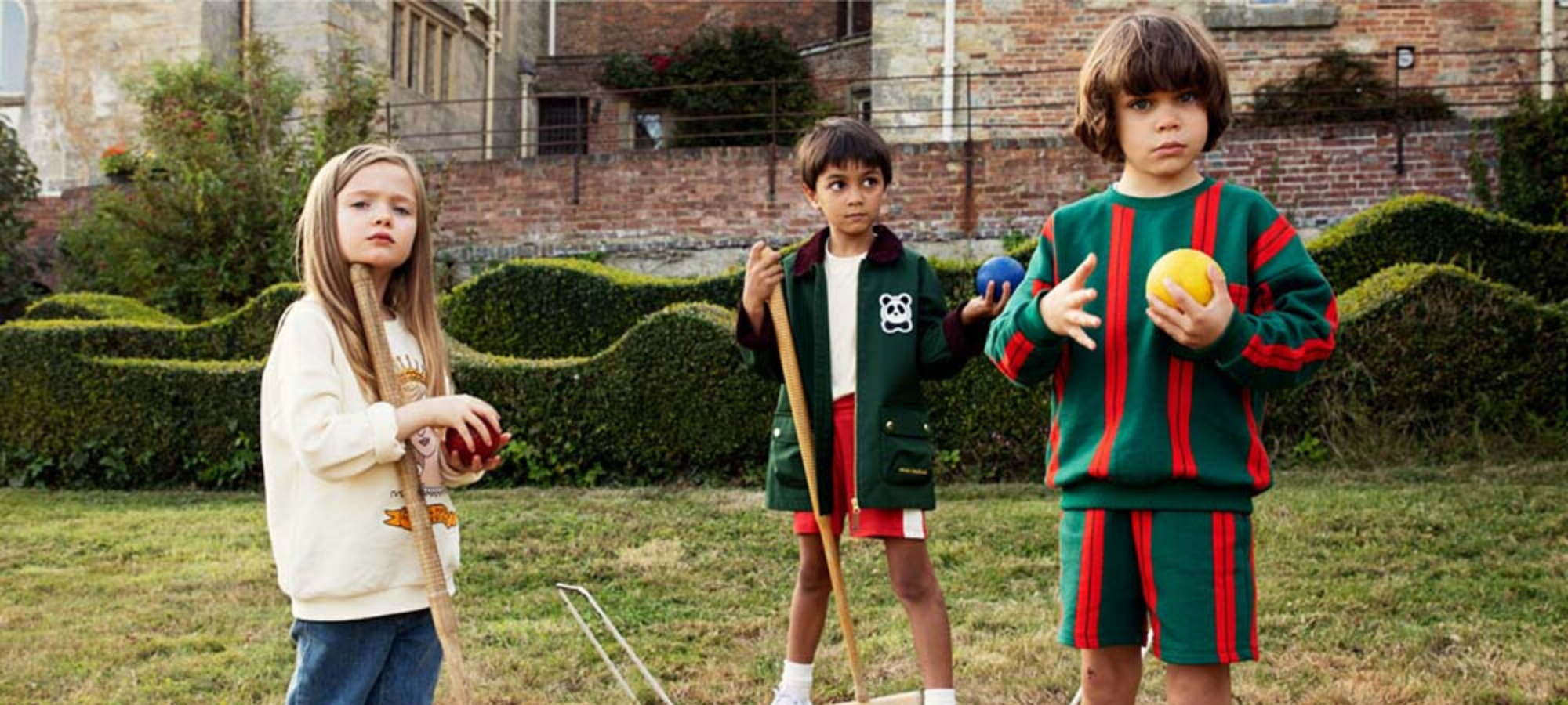 kids wearing mini rodini outfits in garden