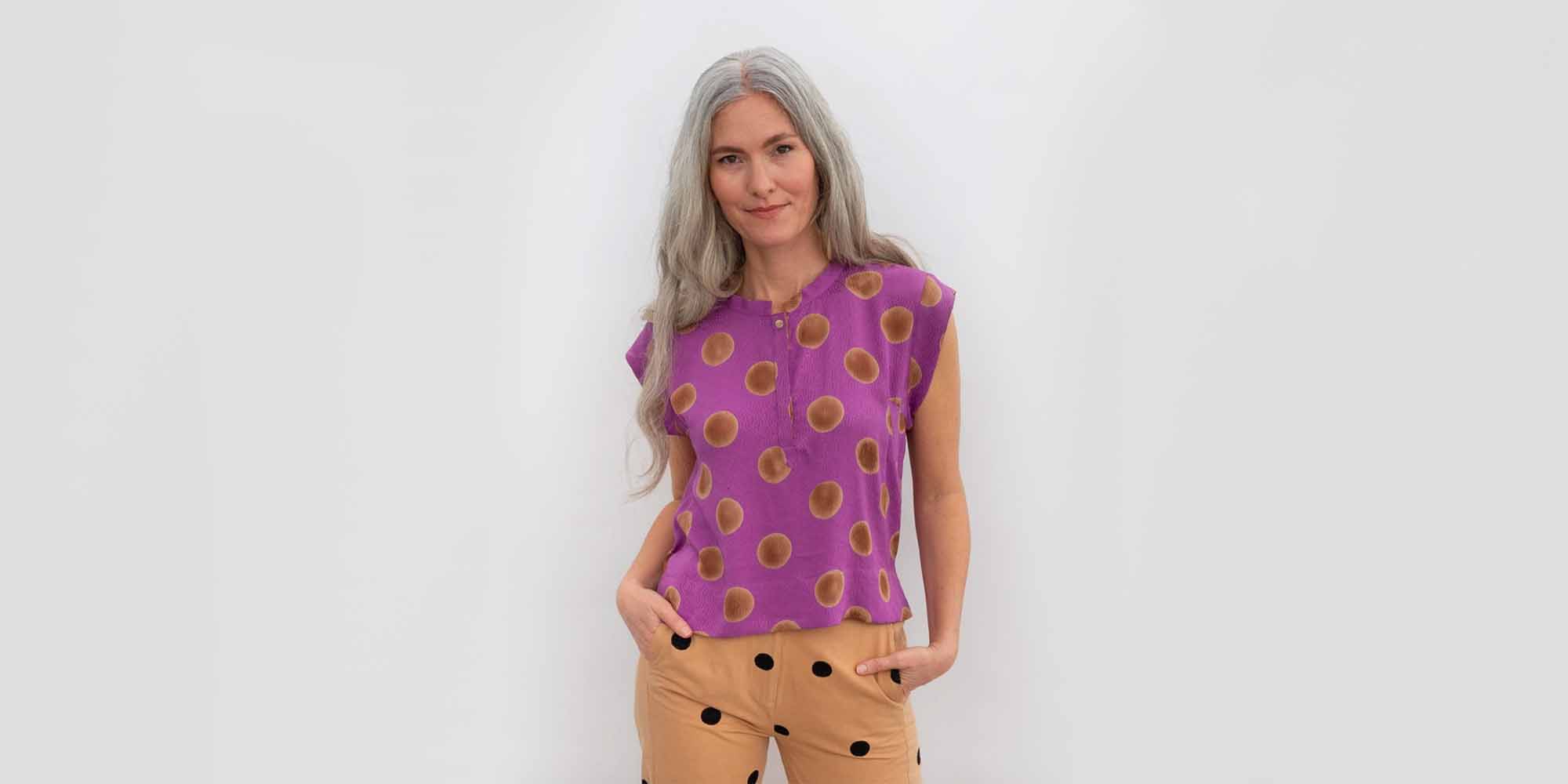 older woman wearing spotted purple top by sustainable fashion brand seek collective