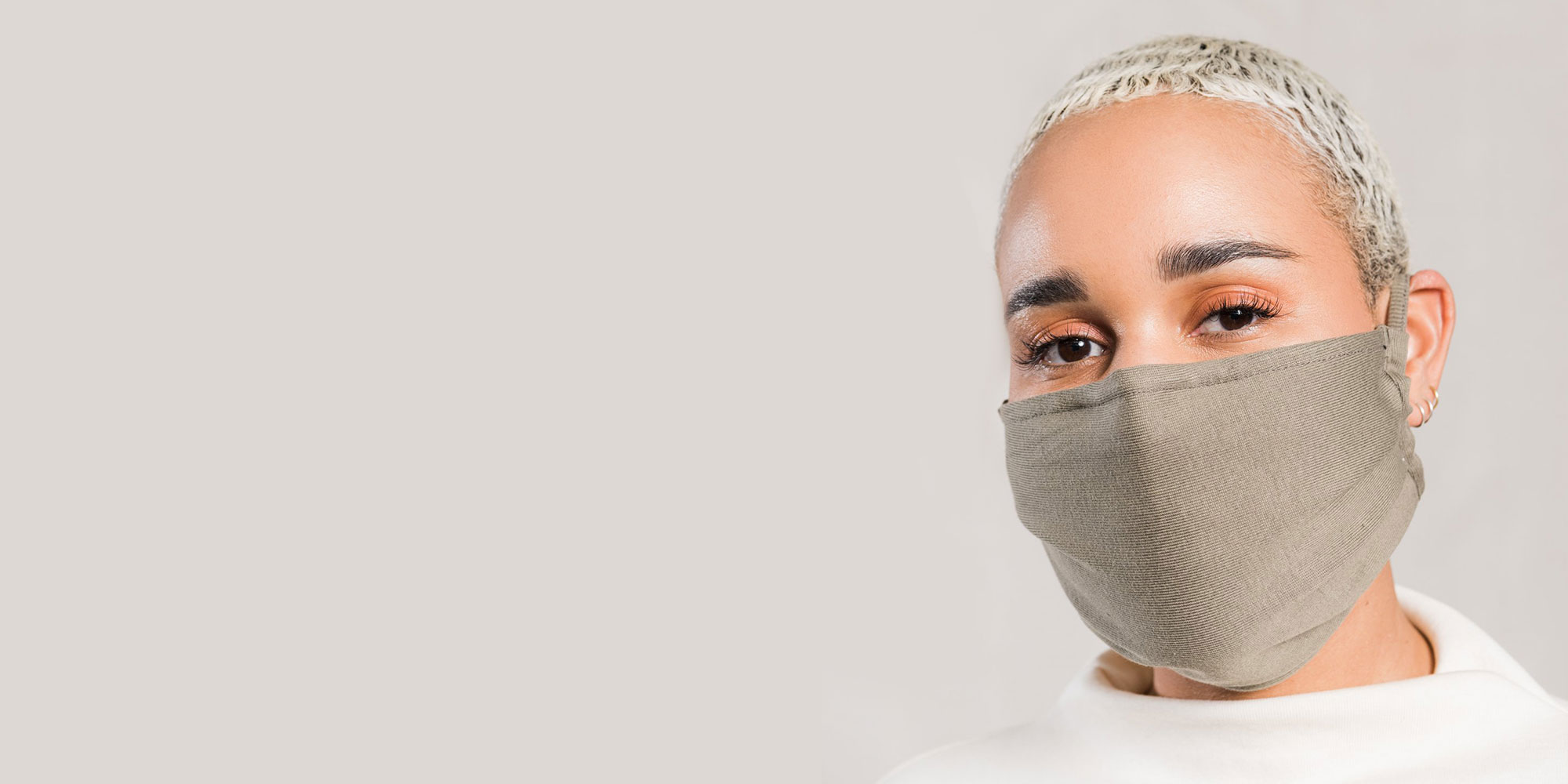 woman wearing beige reusable face mask by abch