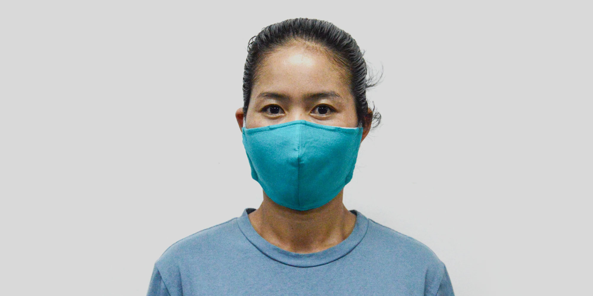 woman wearing bright aqua sustainable face mask by Dorsu