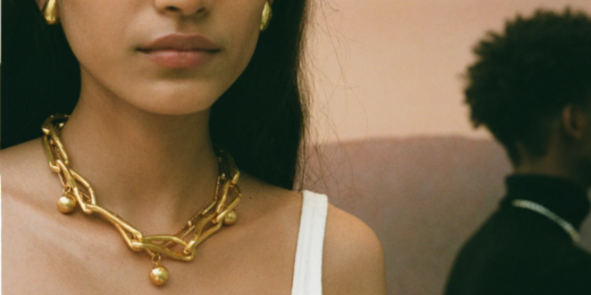 woman wearing sustainably gold necklace and earrings from UK brand Alighieri