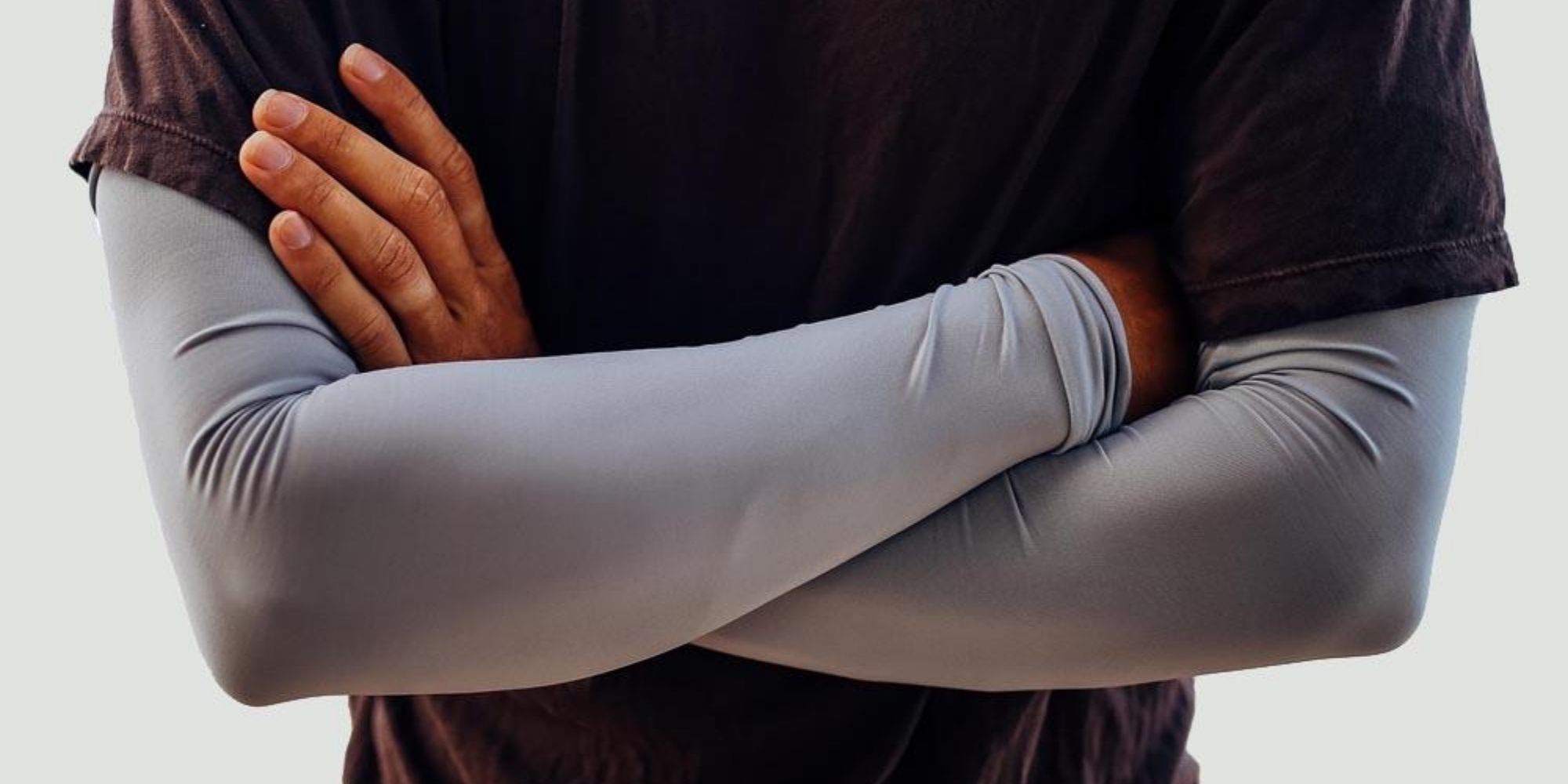 man wearing grey sun sleeves by eclipse brand