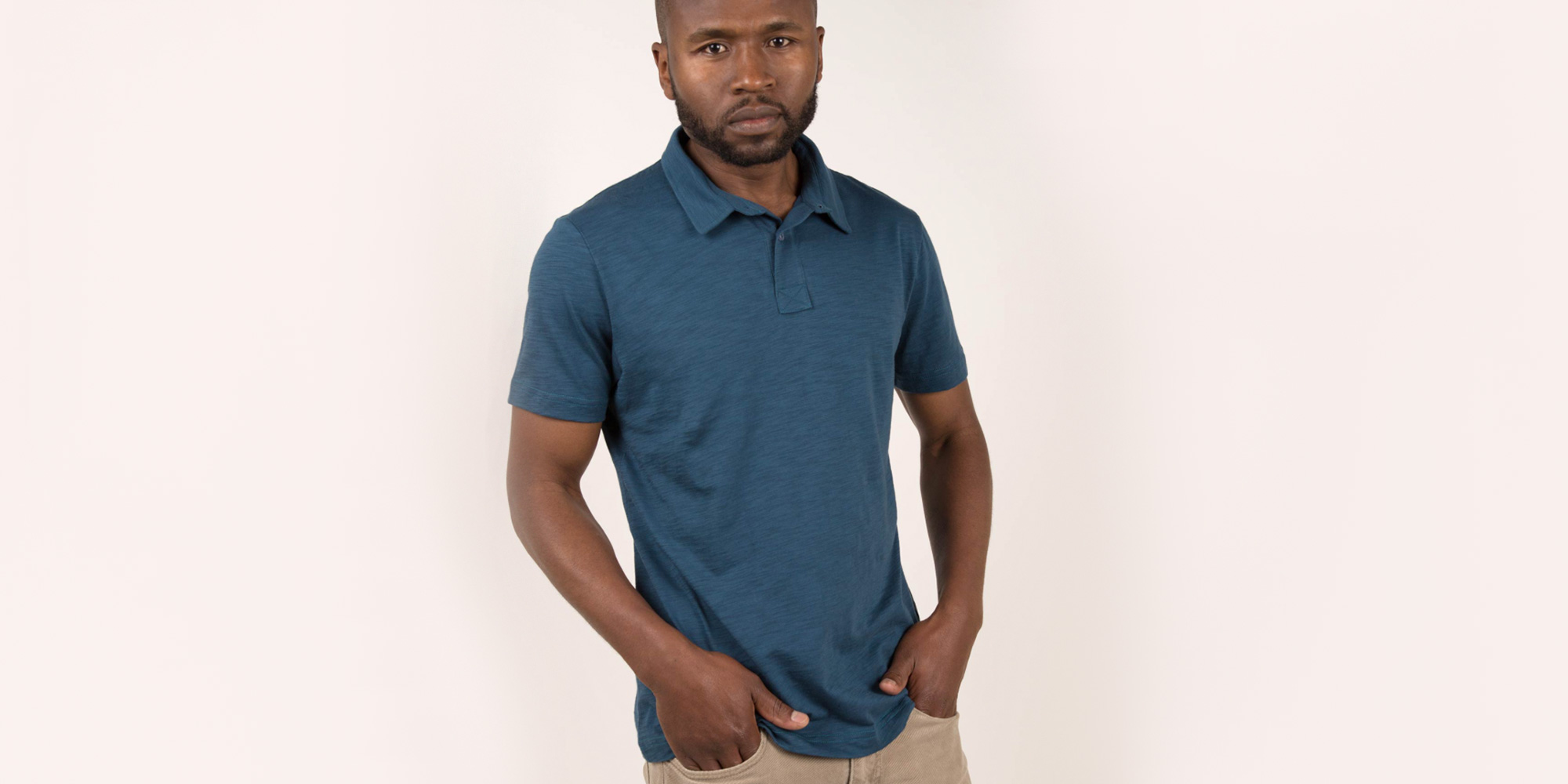 man wearing blue sustainable polo shirt by Indigenous