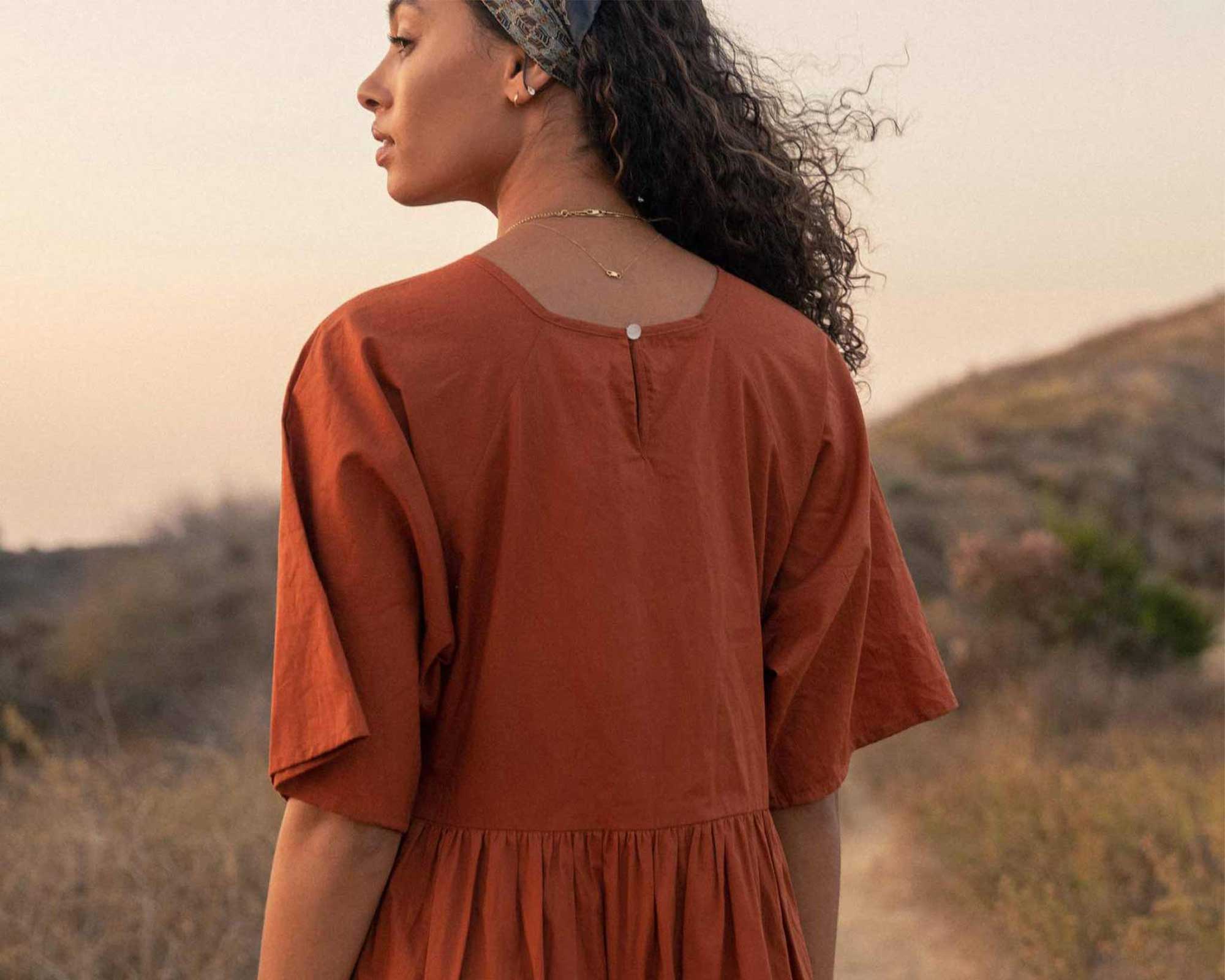 woman wearing sustainable ochre dress by ethical brand Christy Dawn