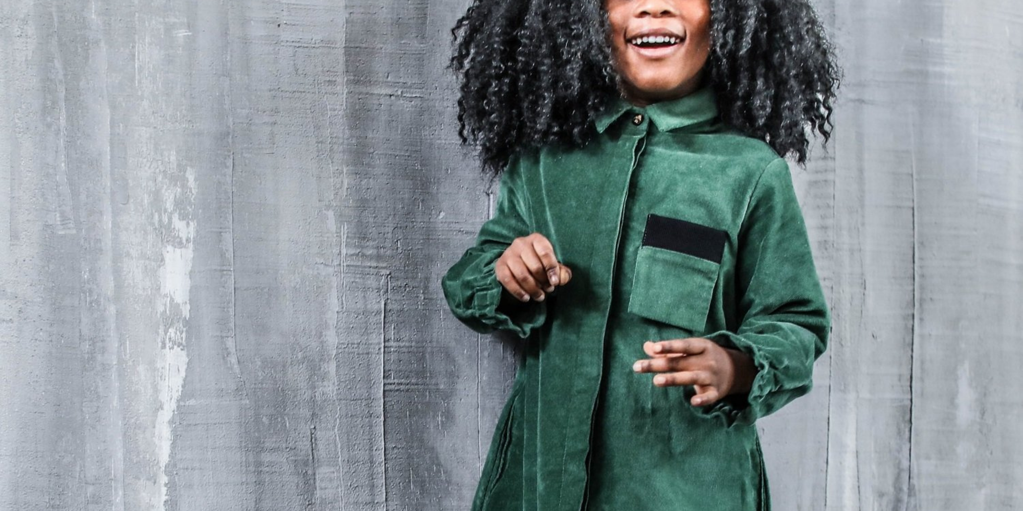 young POC girl wearing preloved green velvet dress by ethical vegan brand Infantium Victoria
