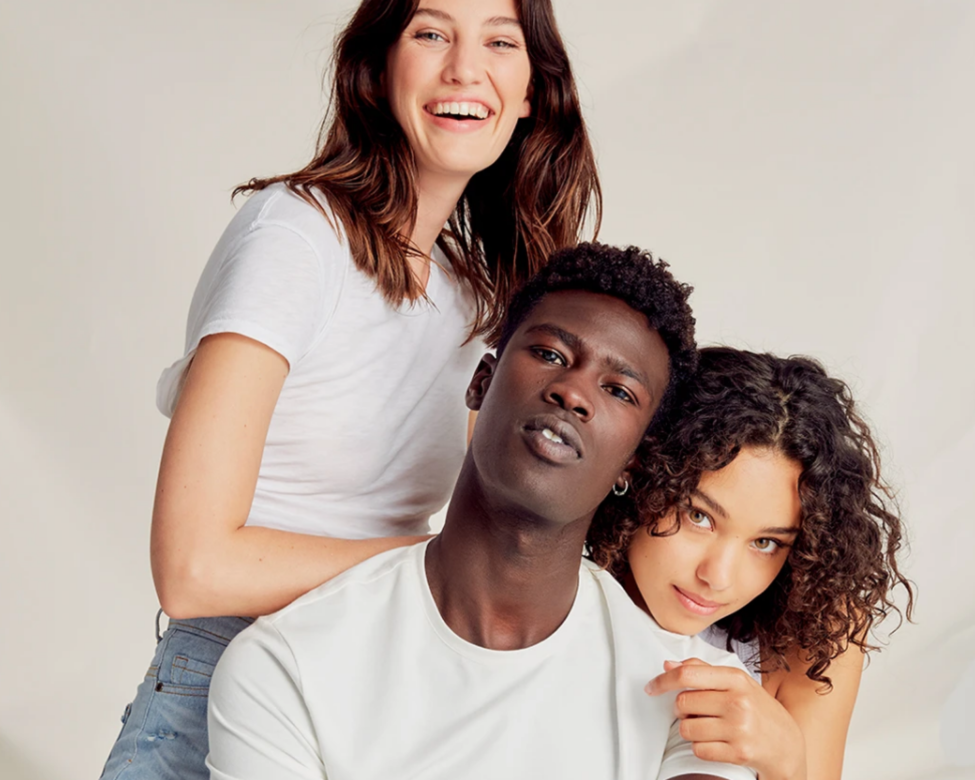 three people looking happy wearing ethical denim brand Outland Denim