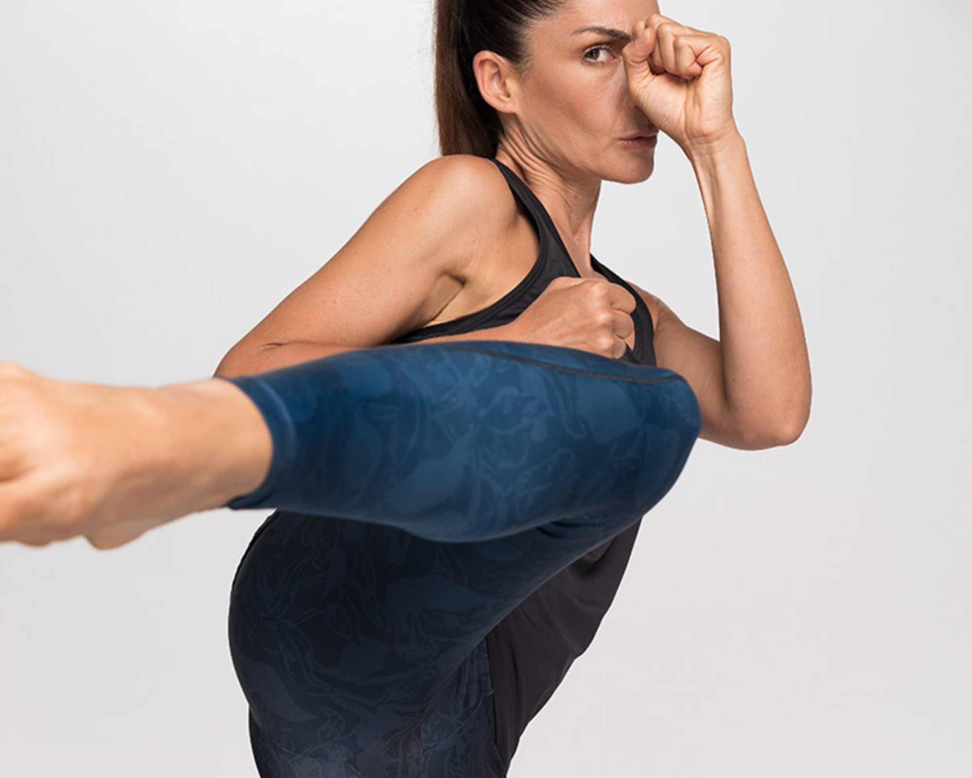 woman kicking the camera wearing sustainable blue activewear by CasaGIN brand