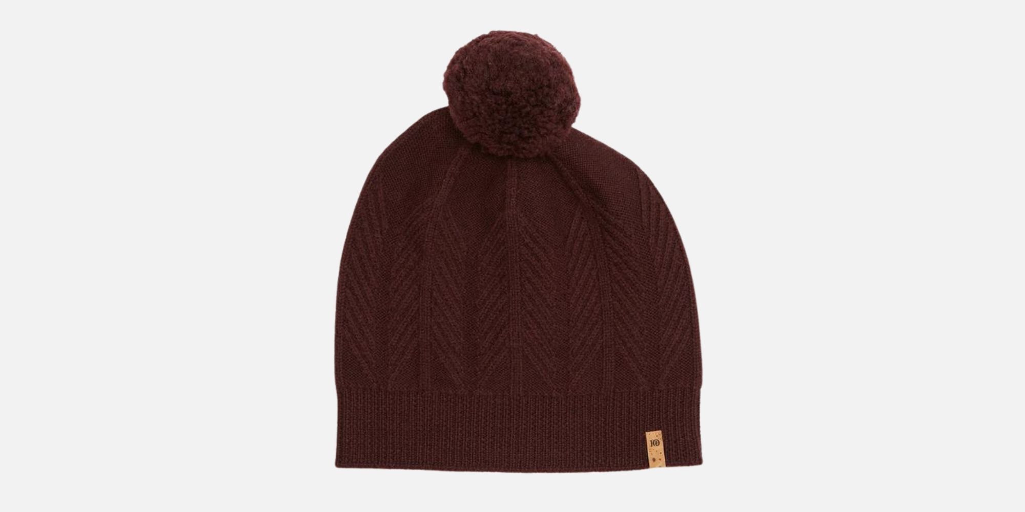 A red wool beanie with a pompom, ethically made by tentree in Canada.