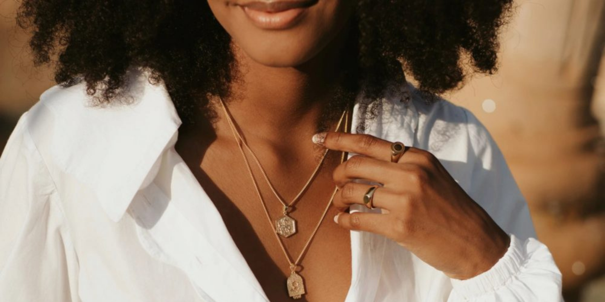 black woman wearing sustainable gold jewellery by LUNA & ROSE brand