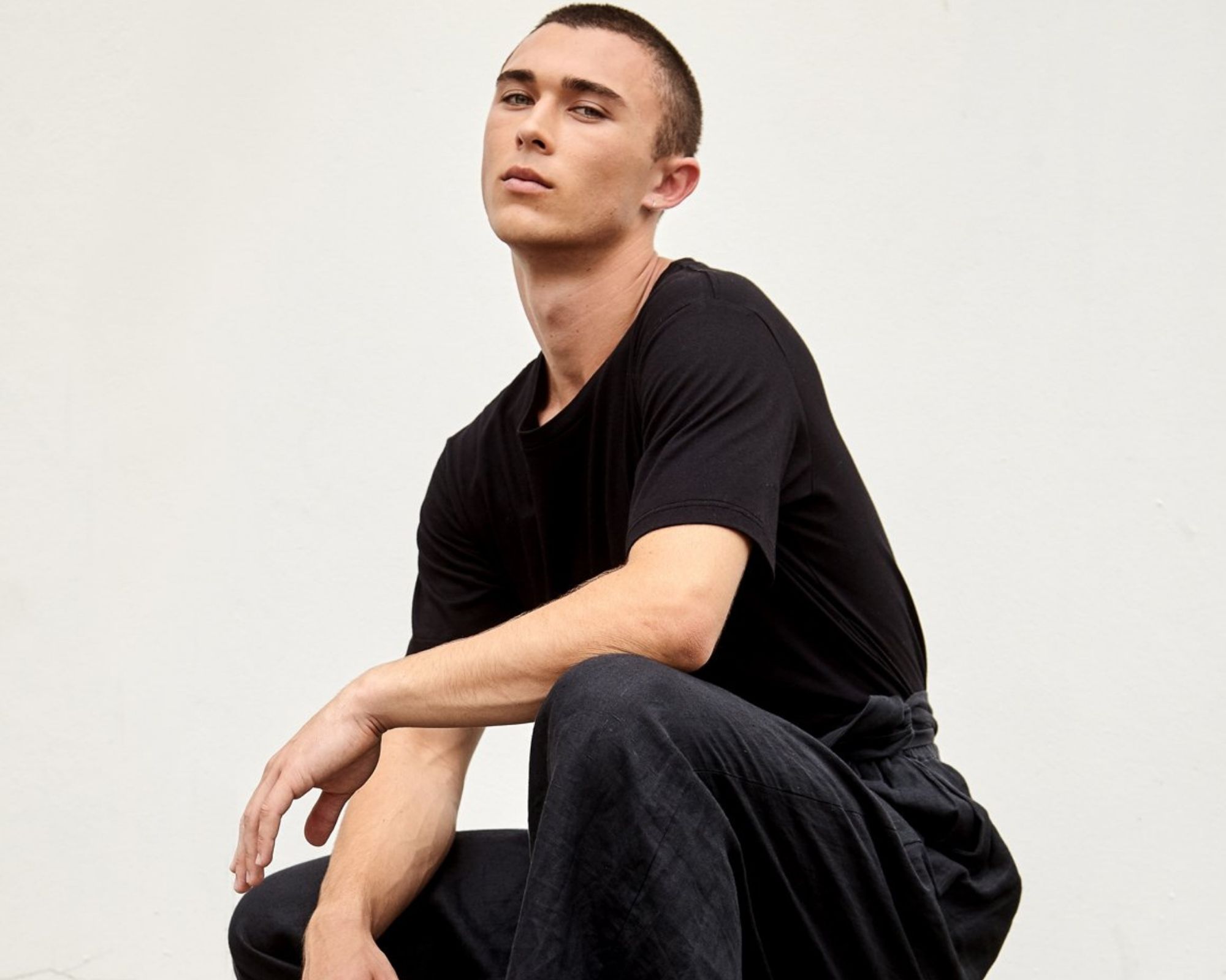 person crouching in black sustainable clothes made by A.BCH