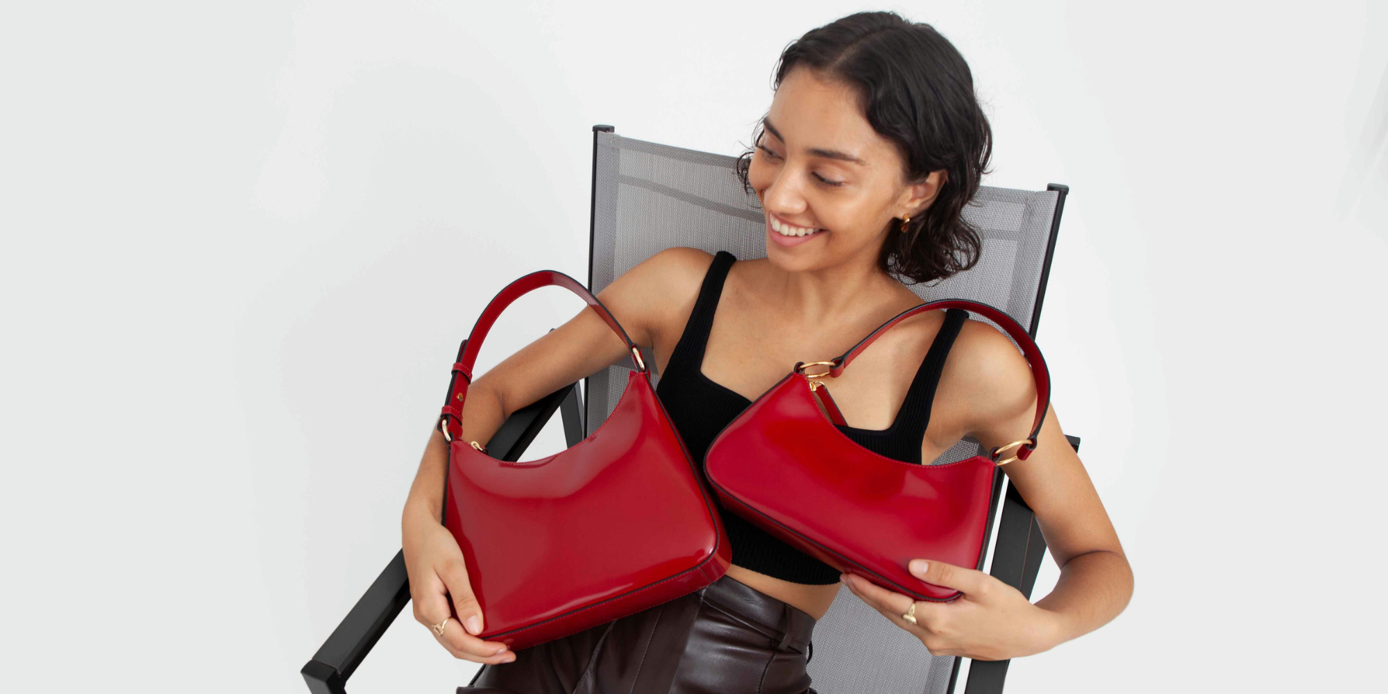 Someone holding one square handbag and one baguette handbag by Hyer Goods.