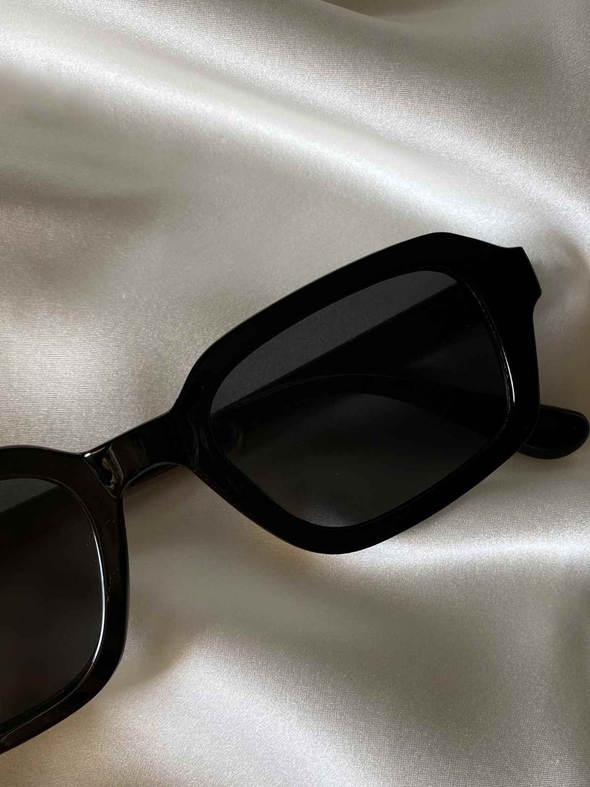 Sunglasses on shiny fabric