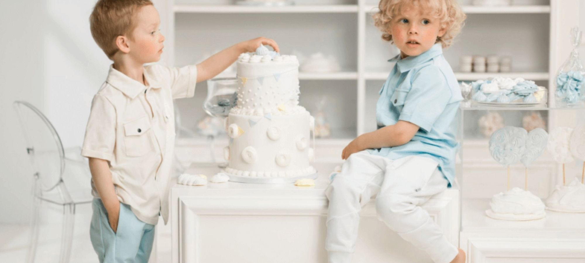 two kids wearing white and blue sustainable baby clothes from Gugguu