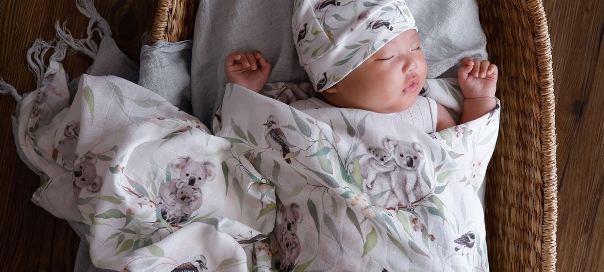 baby wearing organic swaddling with floral print by THEA WITH LOVE