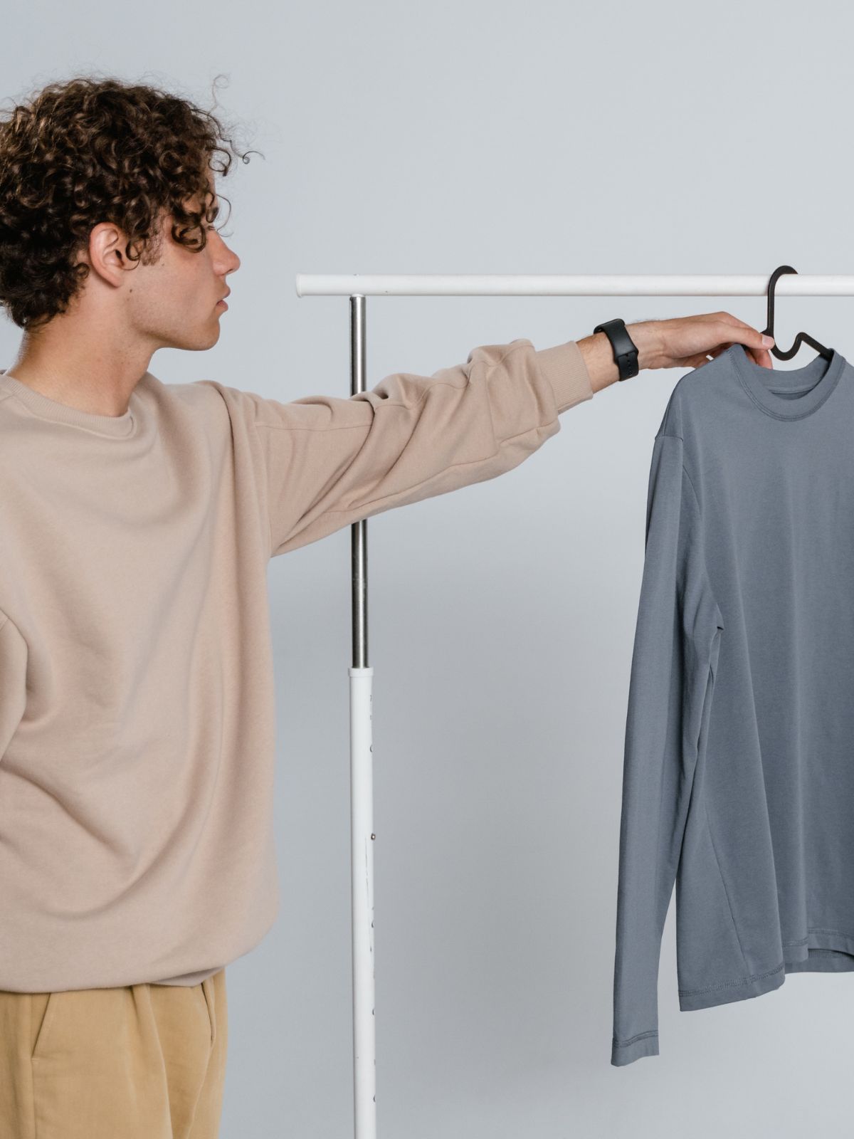 person reaching for t-shirt on a hanger