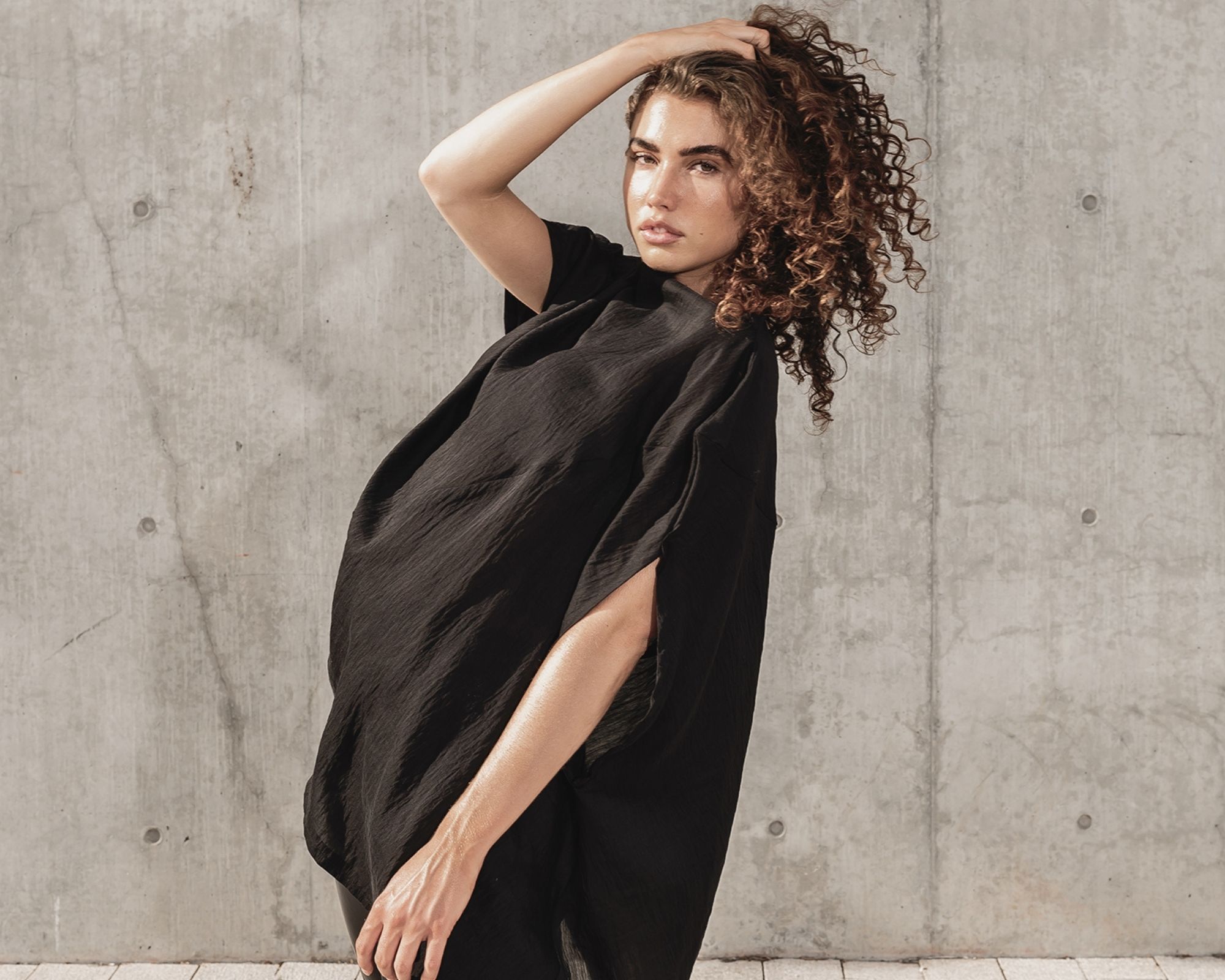 woman of colour wearing black zero waste shirt by Malaika New York