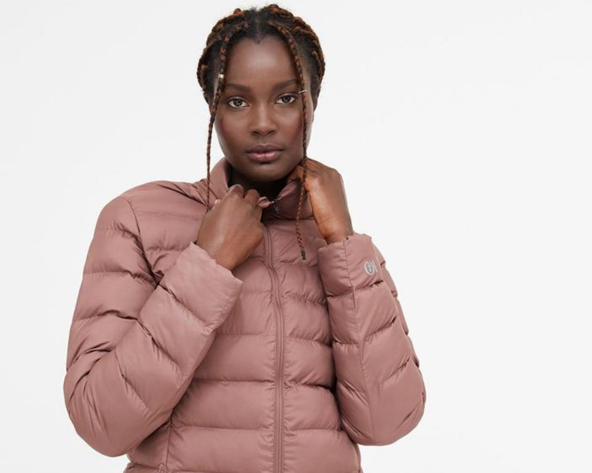 black woman wearing pink packable sustainable puffer jacket by tentree