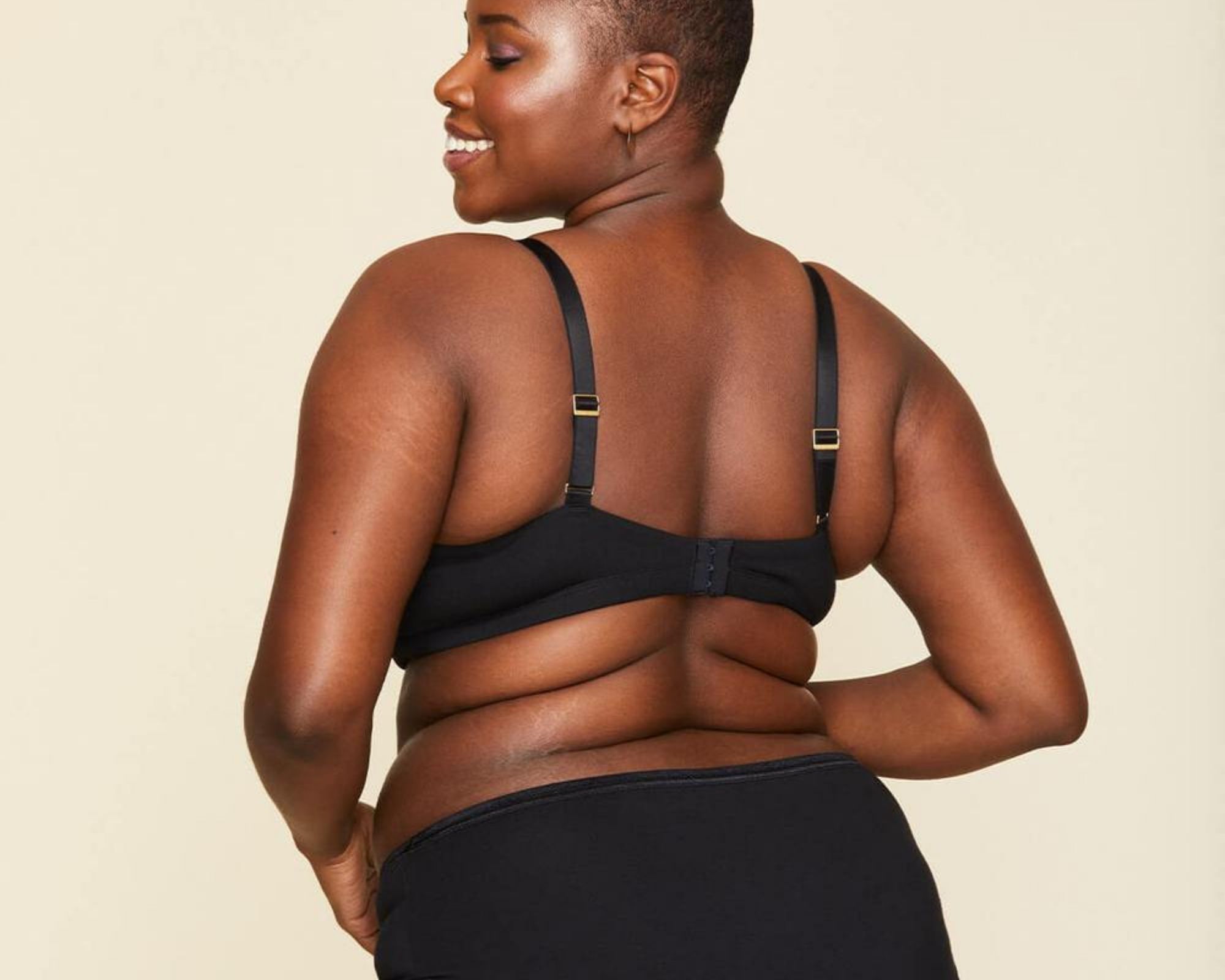 Person from behind wearing a black set of sustainable underwear and bralette ethically made by Knickey.