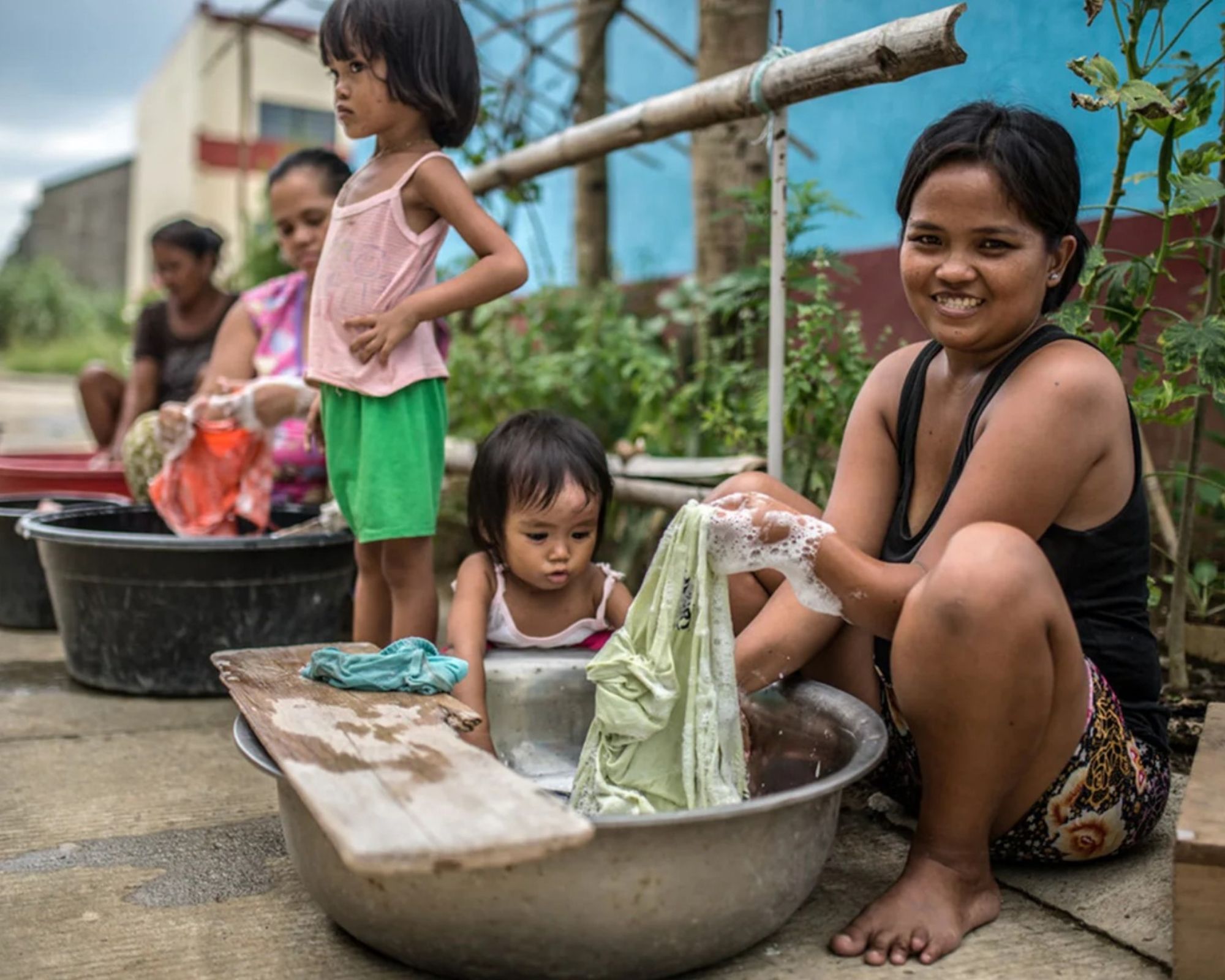 Person and their child washing in clean water through the help of LVRSustainable and Oxfam Italia initiative.