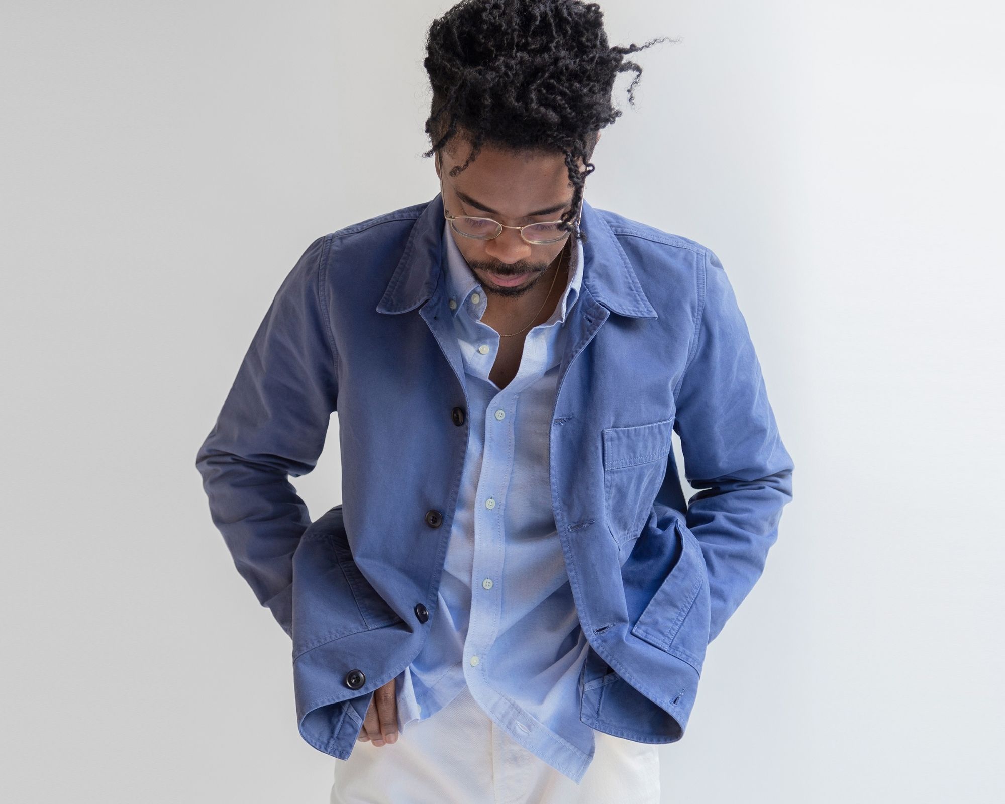 Someone looking down and wearing blue unisex apparel, ethically made by Unrecorded.