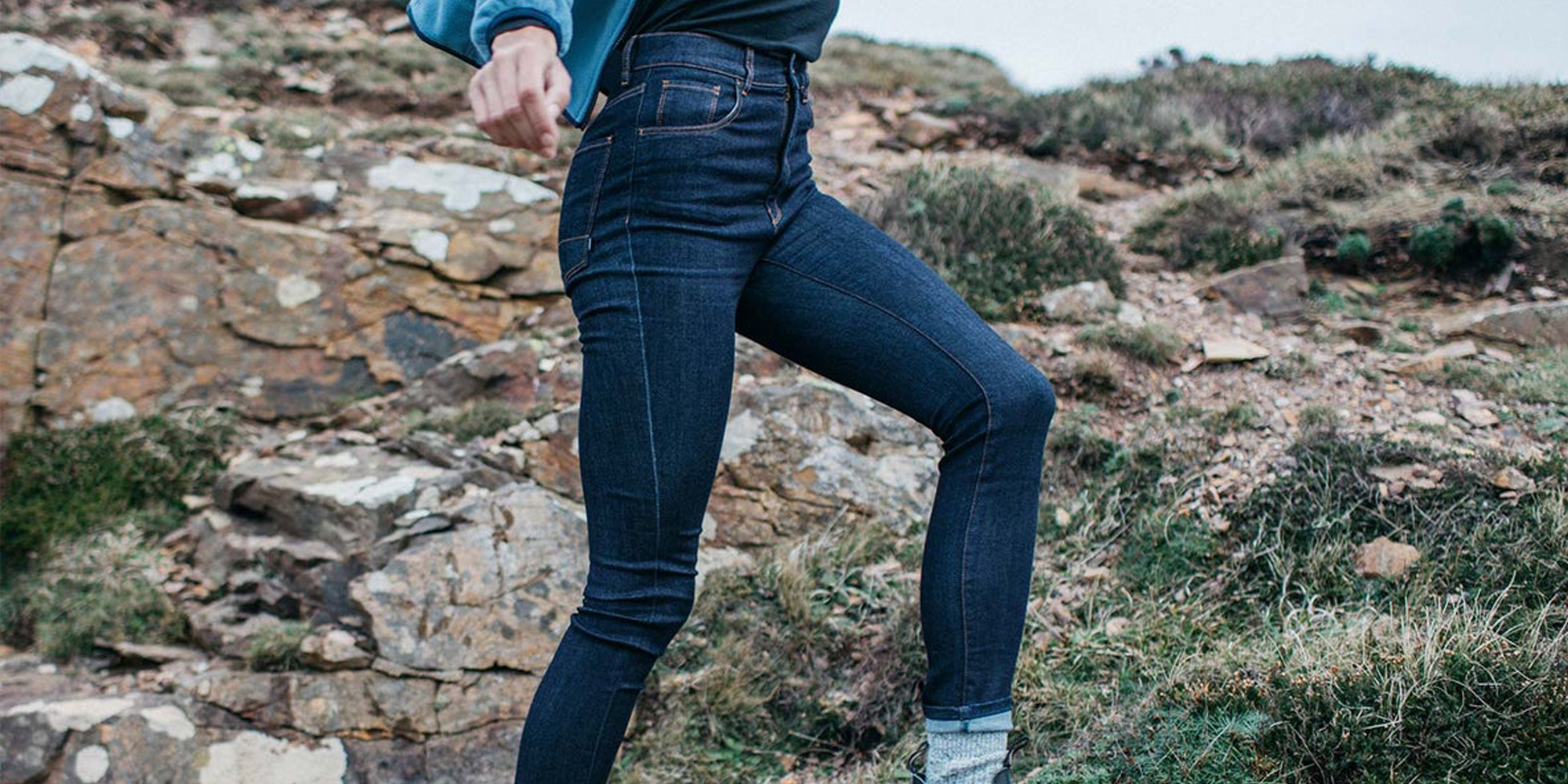 Someone outdoors wearing dark blue skinny jeans ethically made in the UK by Finisterre.