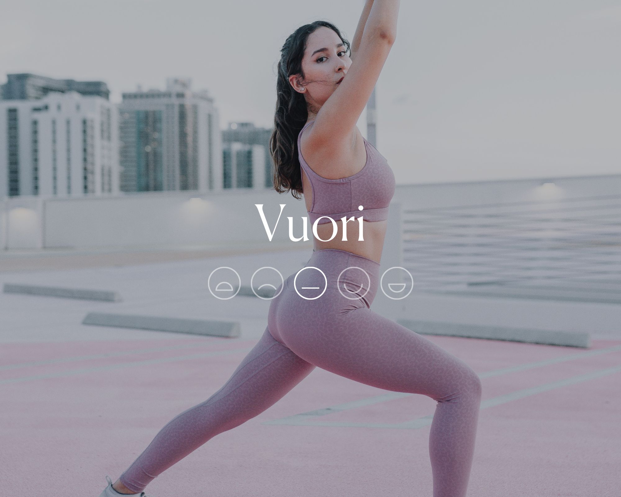 Someone wearing a pink activewear set behind white font reading Vuori with a neutral smiley face emoji beneath it.