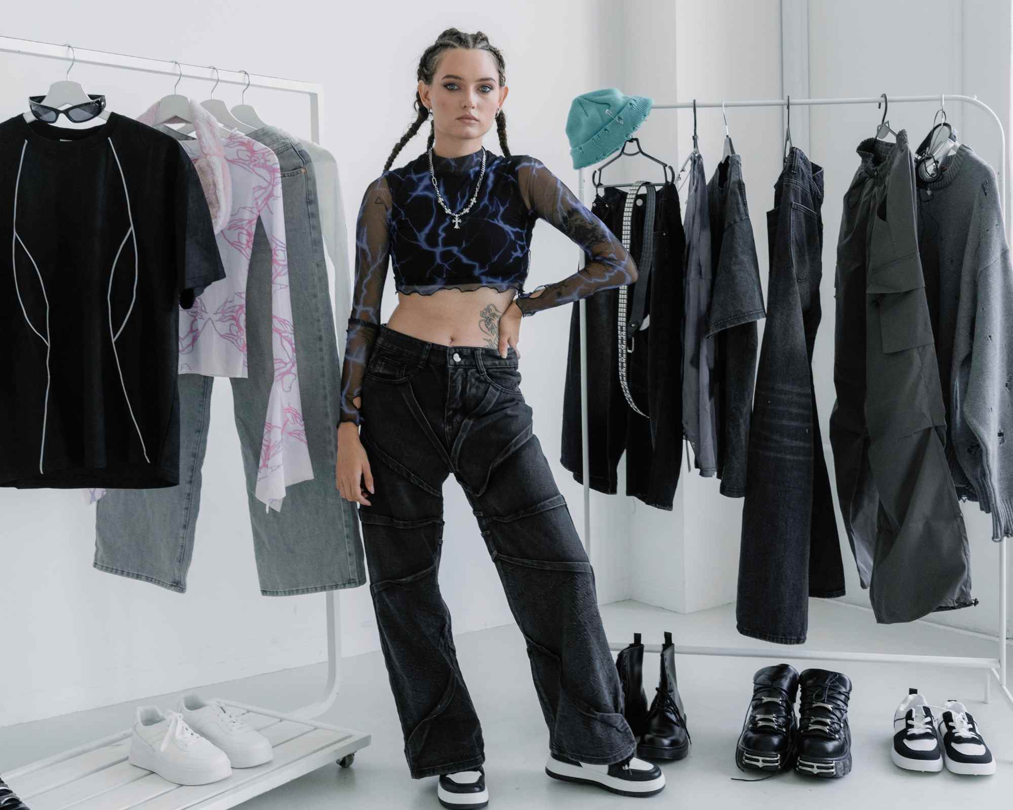 person standing with rails of goth clothing