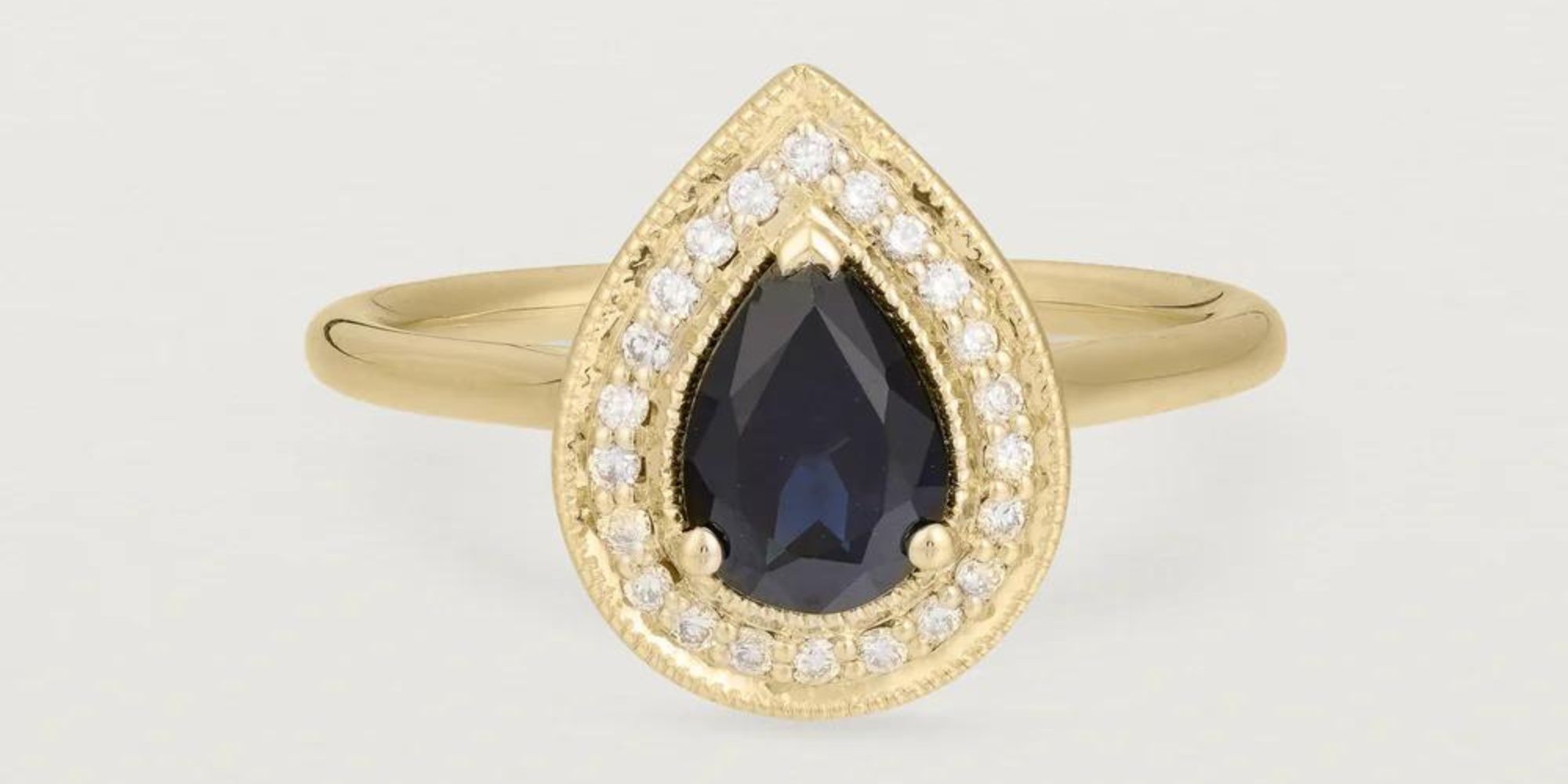 A gold halo engagement ring by Natalie Marie Jewellery featuring an Australian sapphire and diamonds.
