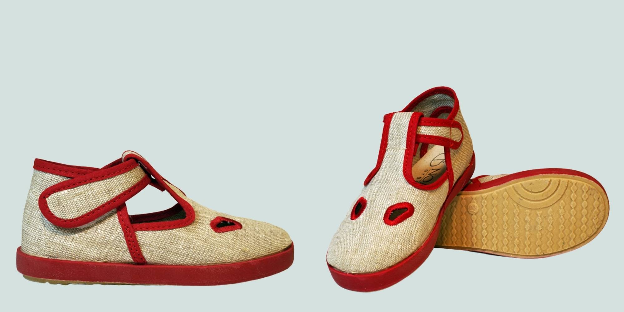 A pair of beige and red childrens shoes by NOAH.