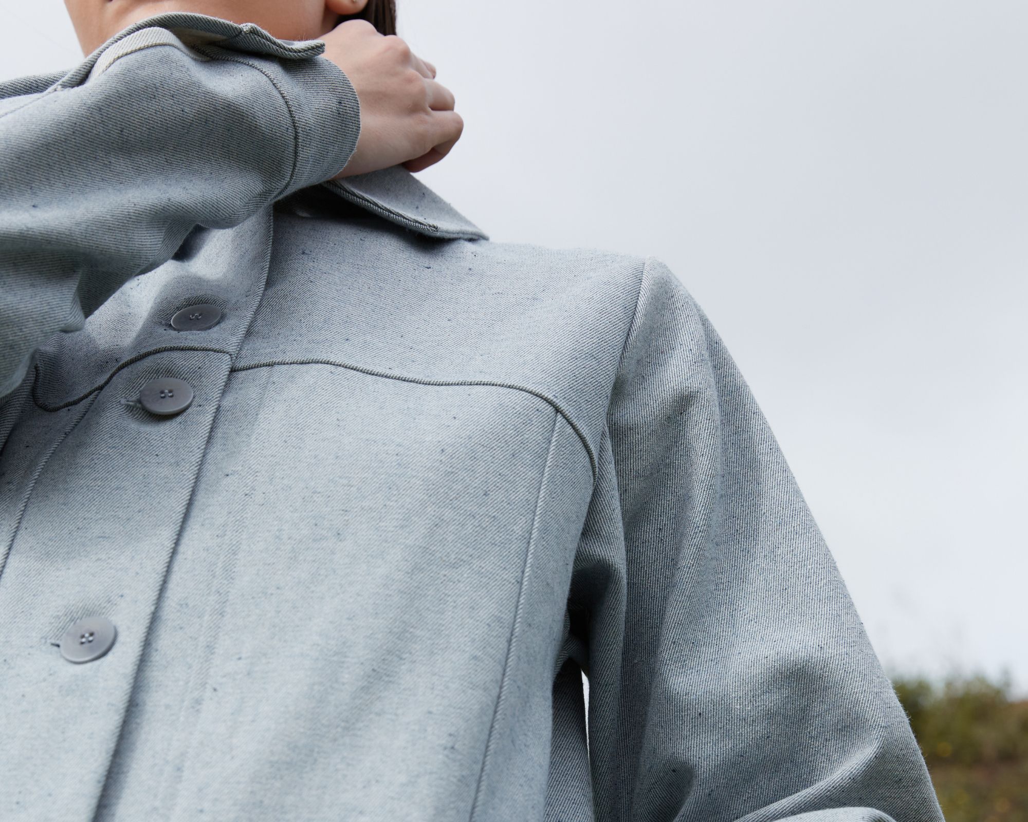 Close up of a light wash recycled denim trench coat responsibly made by A.BCH.