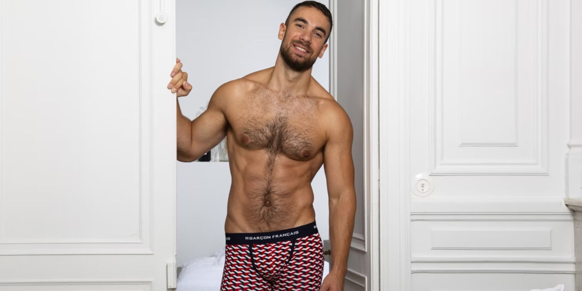 A man wearing red and blue patterned jocks by Garcon Francais.