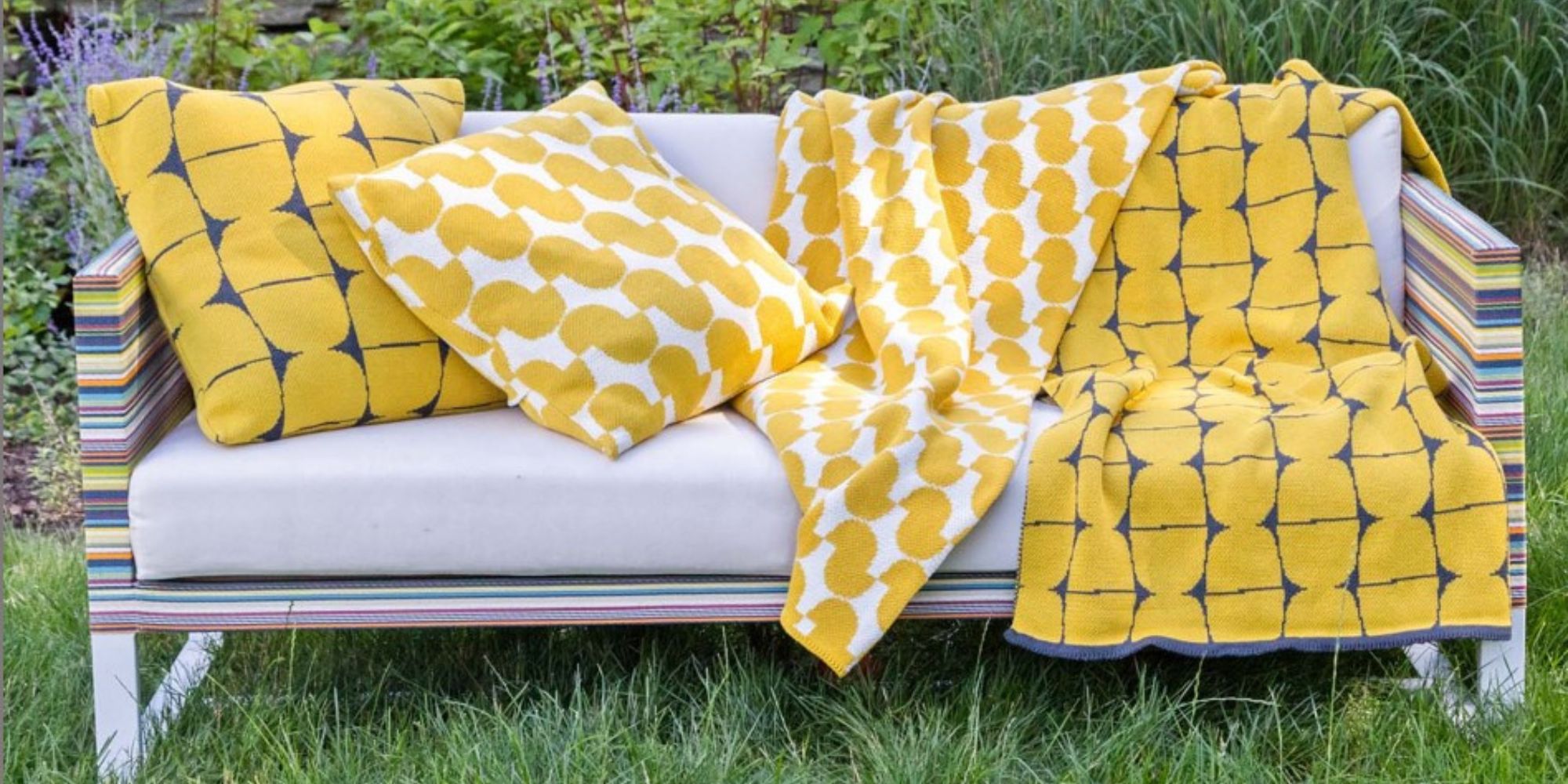 Yellow cushion covers and towels on a couch responsibly designed by In2Green.