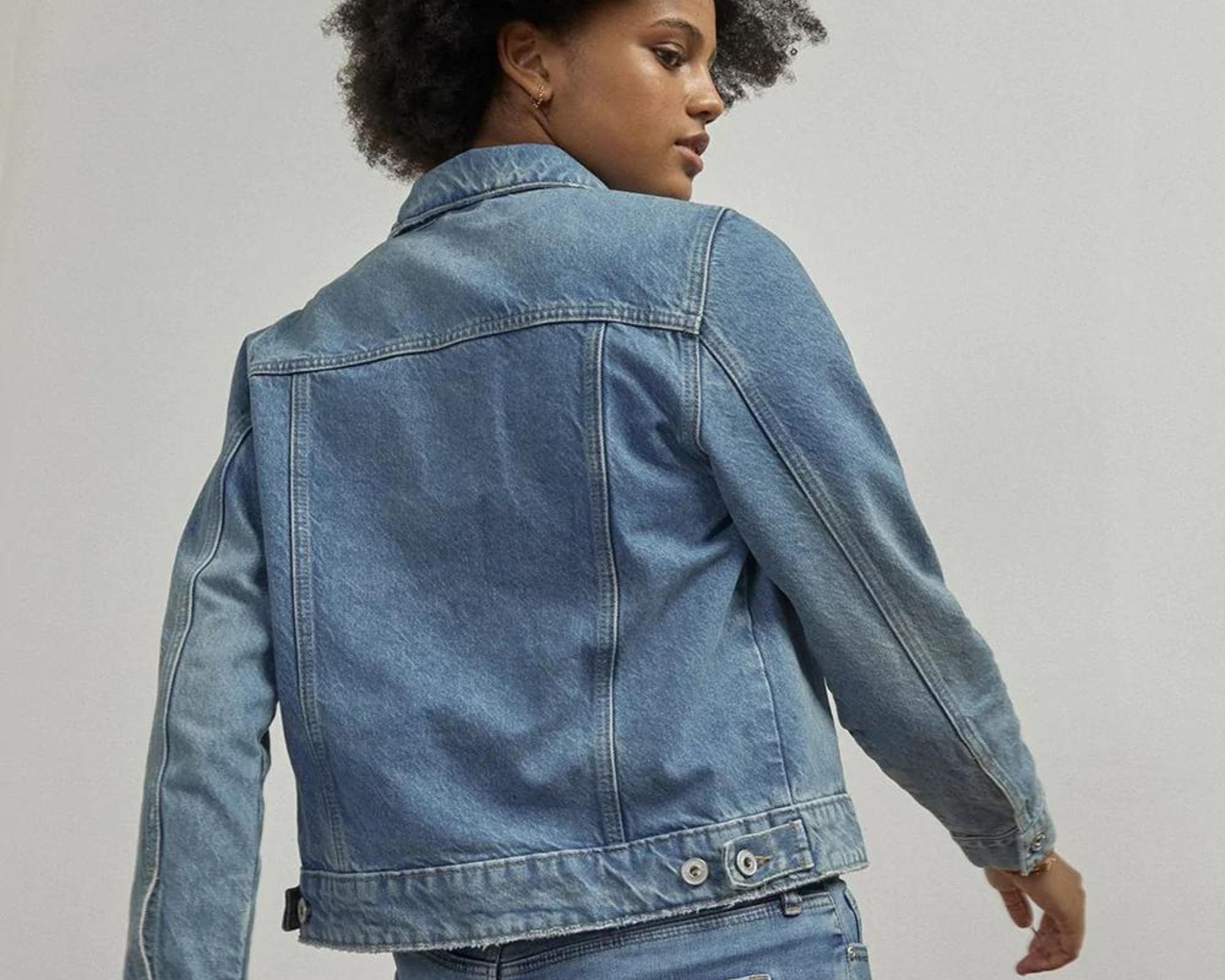 Someone looking over their shoulder wearing an Outland Denim jean jacket and pants.