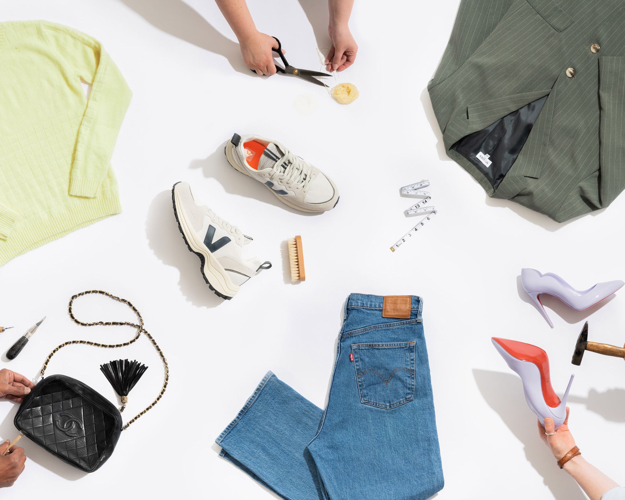 A flat lay of fashion items being repaired by a tailor.