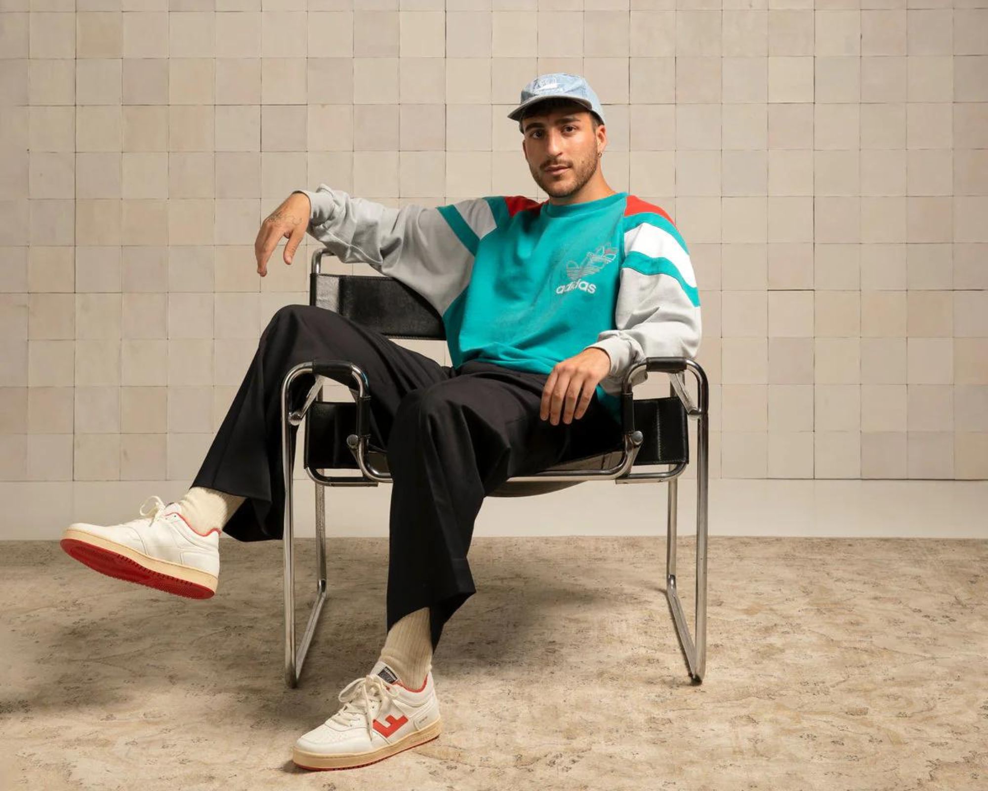 Someone sitting in a chair wearing white vintage style Flamingos' Life sneakers stocked by Good.eco.