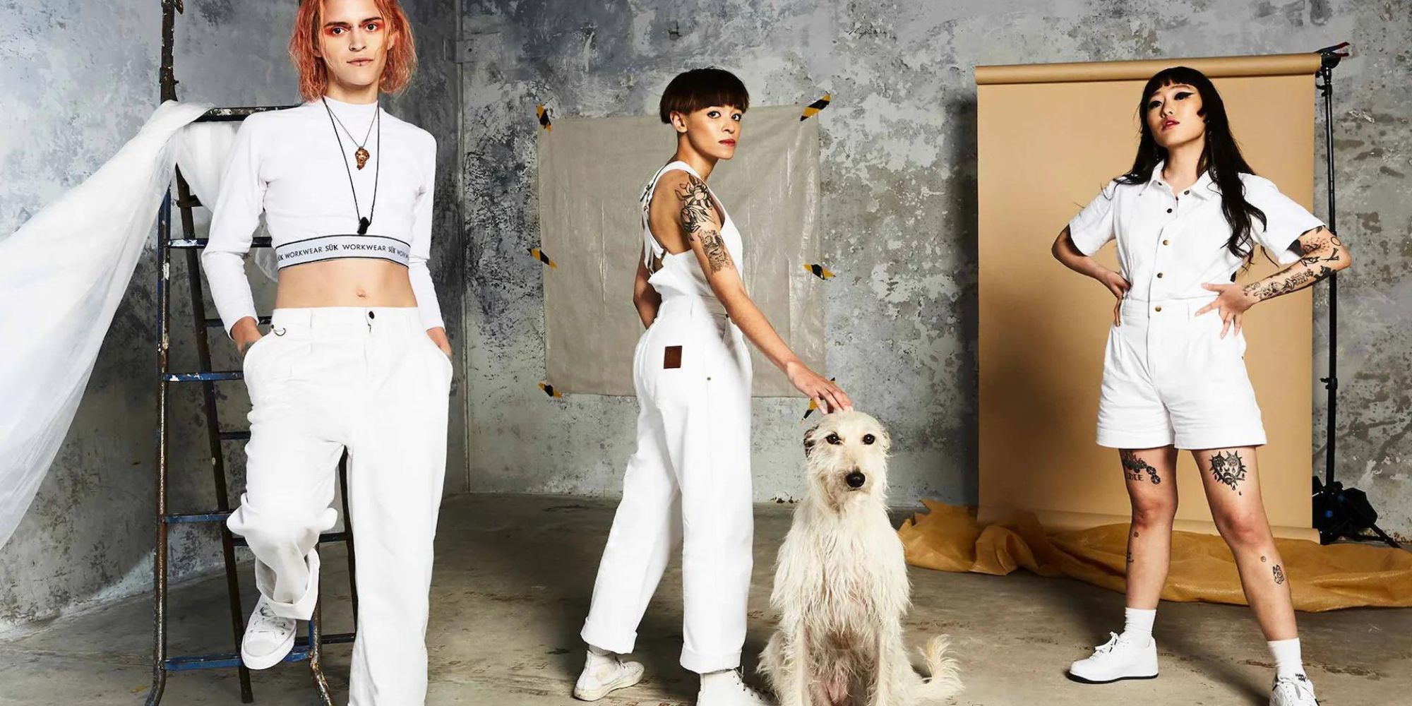 Three people wearing white workwear by Australian label Sük Workwear.
