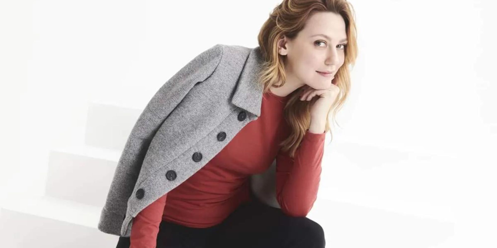 Someone modelling a grey coat and red long sleeve t-shirt by conscious fashion brand Message Factory.