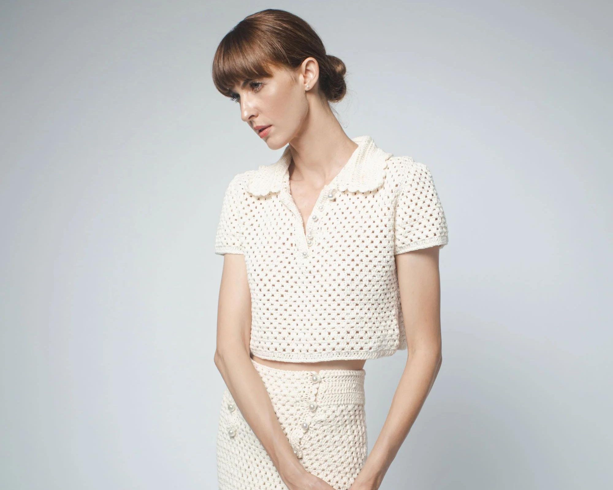 A pearl white hand crocheted polo crop top and skirt by Santicler.