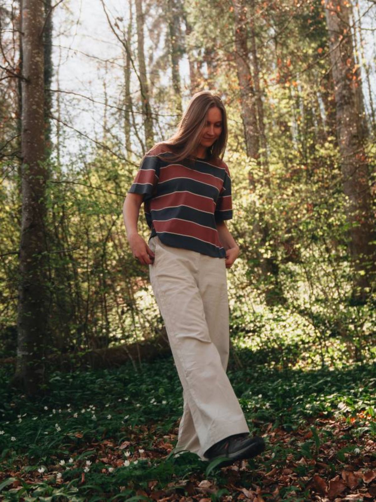 person wearing striped top and beige jeans from nikin, a more sustainable brand from switzerland