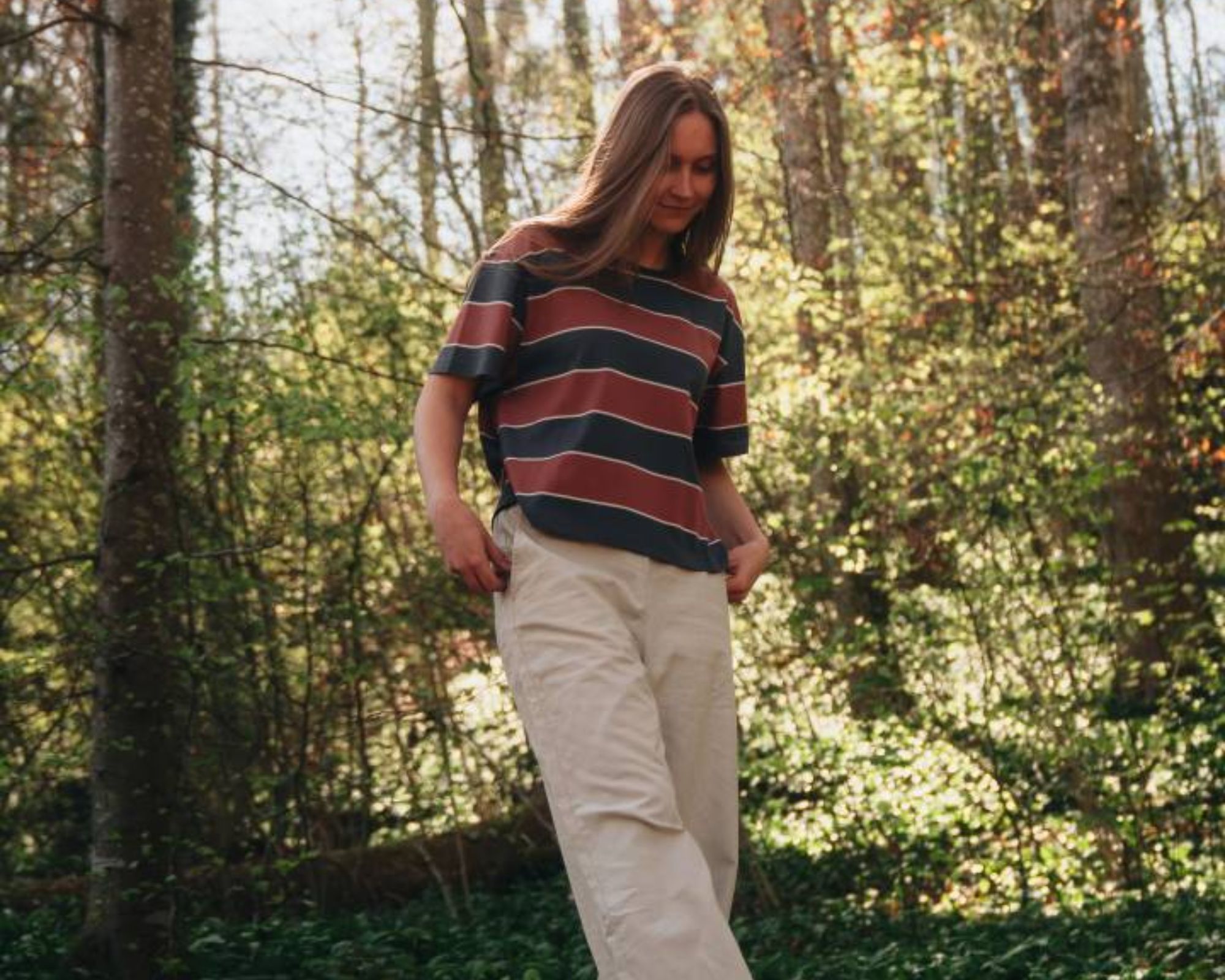 person wearing striped top and beige jeans from nikin, a more sustainable brand from switzerland