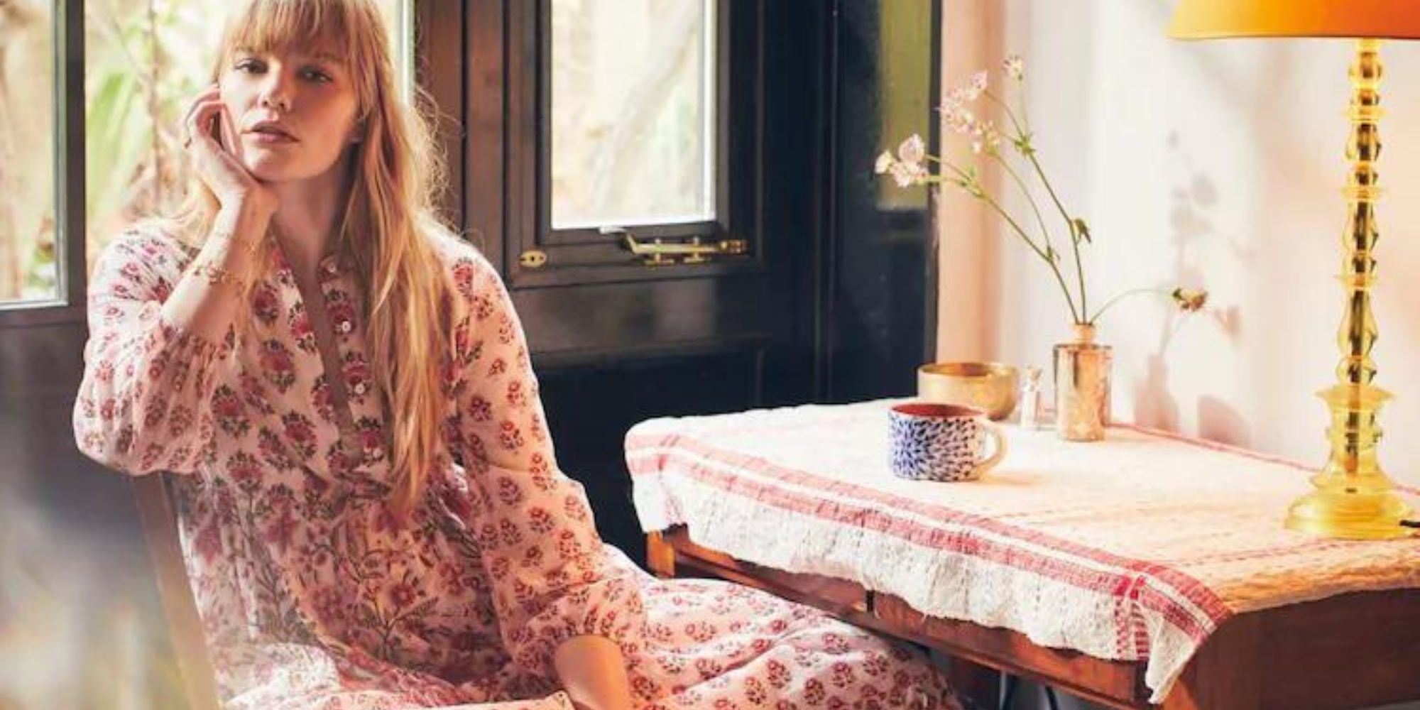 Someone lounging while wearing a red and white patterned dress by Dilli Grey.