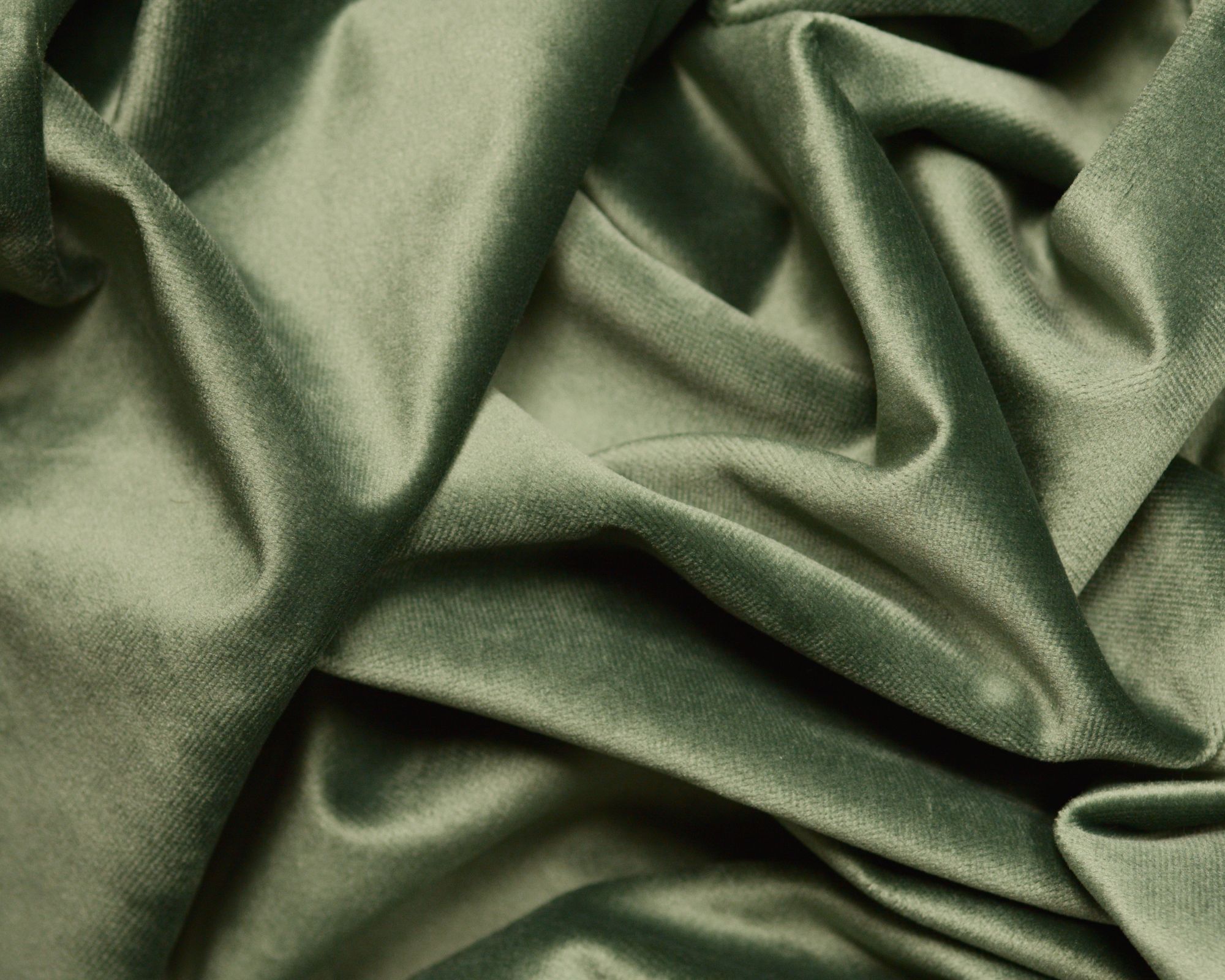 A close up of folds of green velvety fabric.