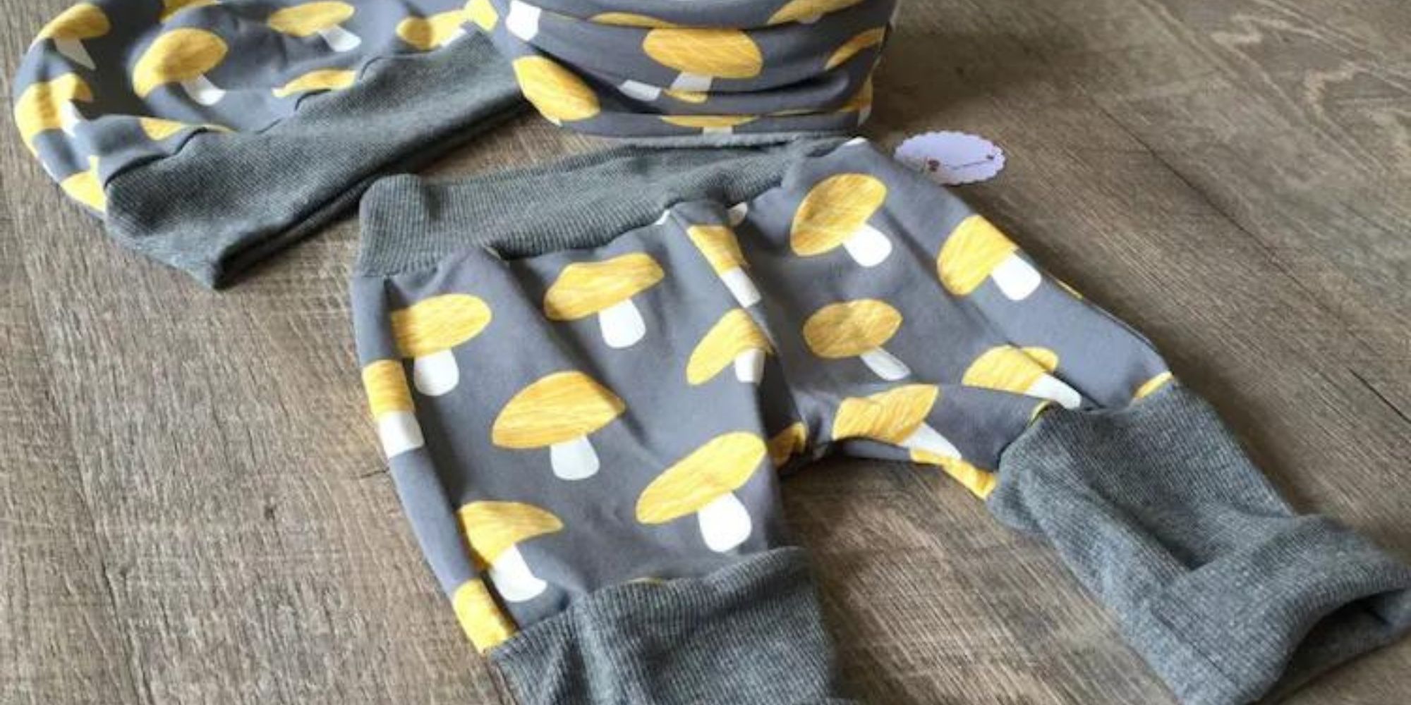 Responsibly-made baby clothes in grey with yellow mushrooms by German brand les boutons.