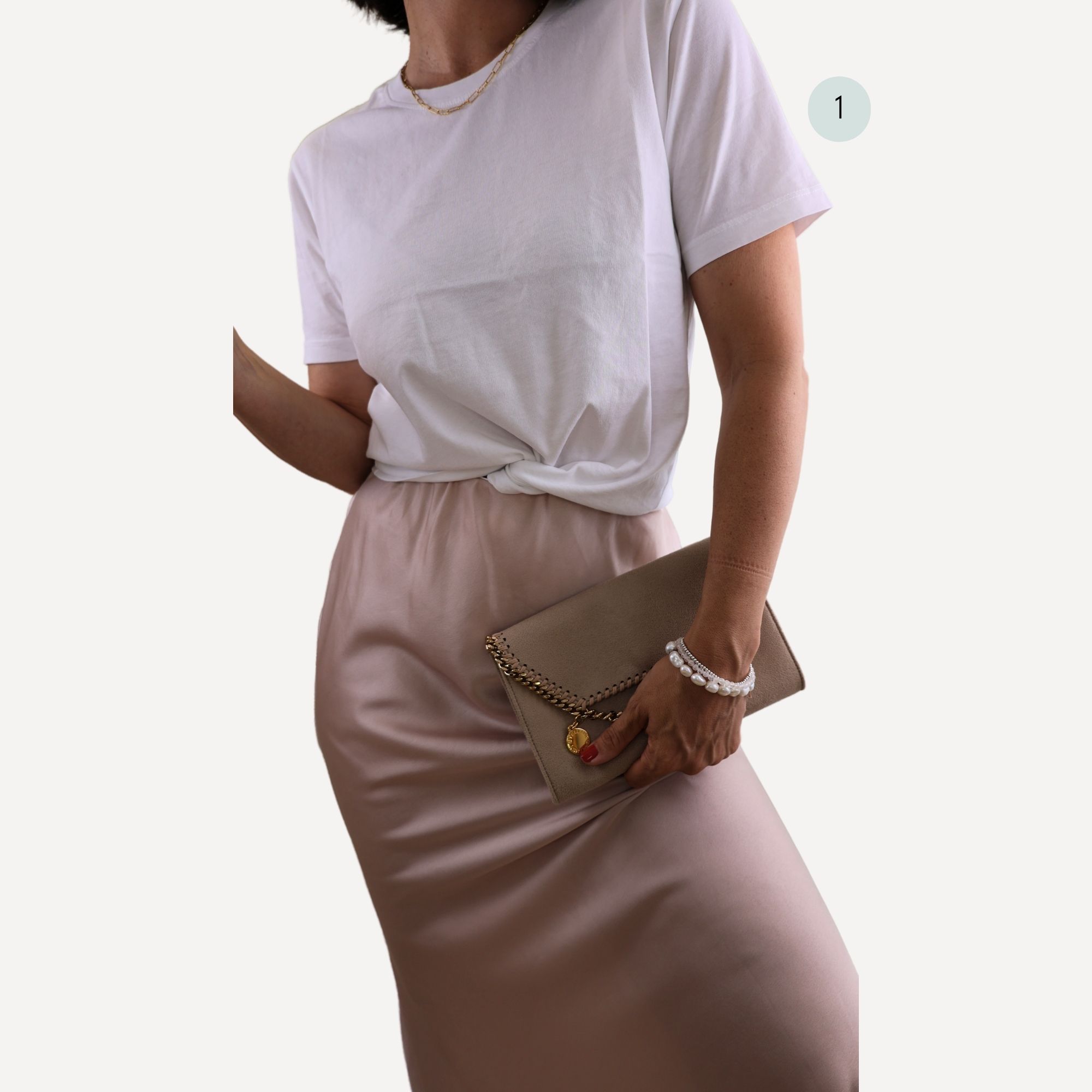 A feminine chic look pairing a white organic cotton fair trade Classic T-Shirt tee with a pink silky skirt and low heels.