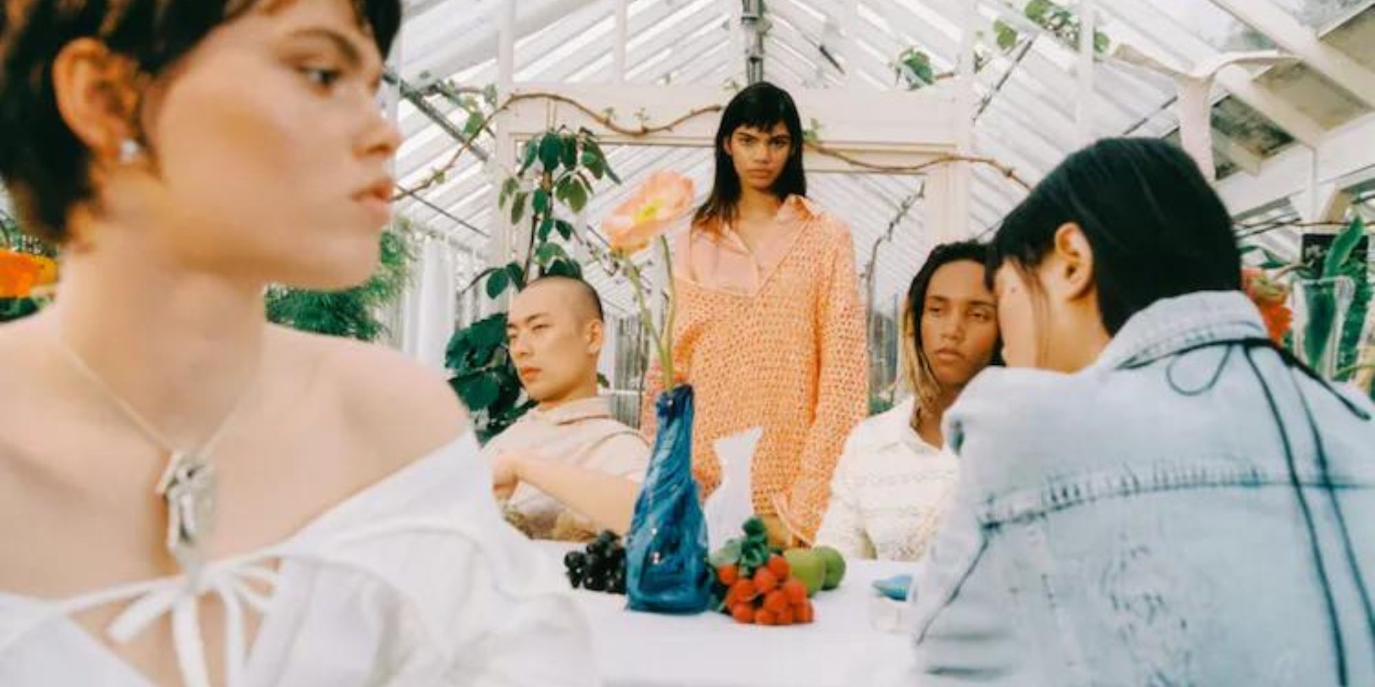 A group of people around a table wearing Holzweiler ready-to-wear fashion.