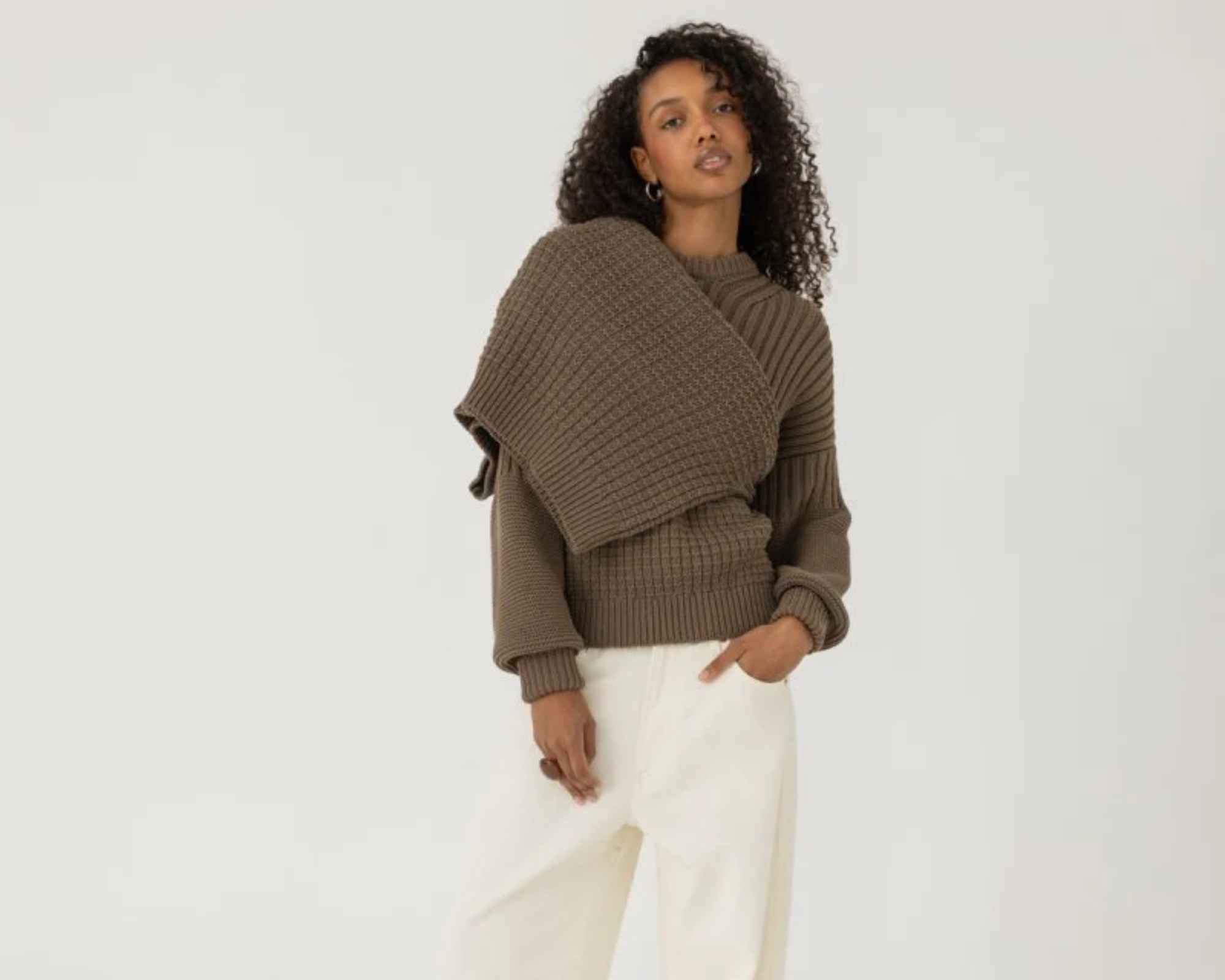 person wearing chunky knit sweater from more sustainable brand the knotty ones